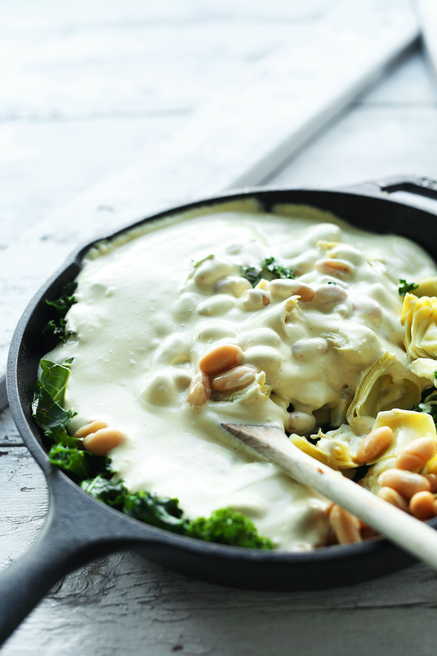 Stirring together ingredients for our amazing Kale & White Bean Artichoke Dip recipe