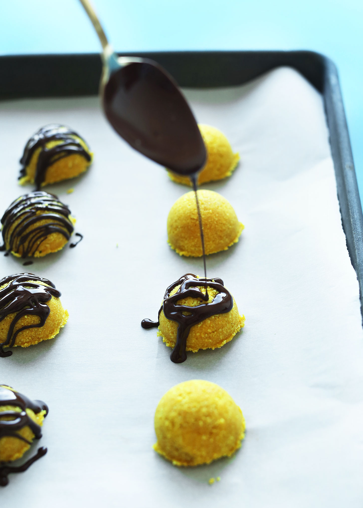 Drizzling chocolate sauce onto our gluten-free vegan Golden Milk Macaroons