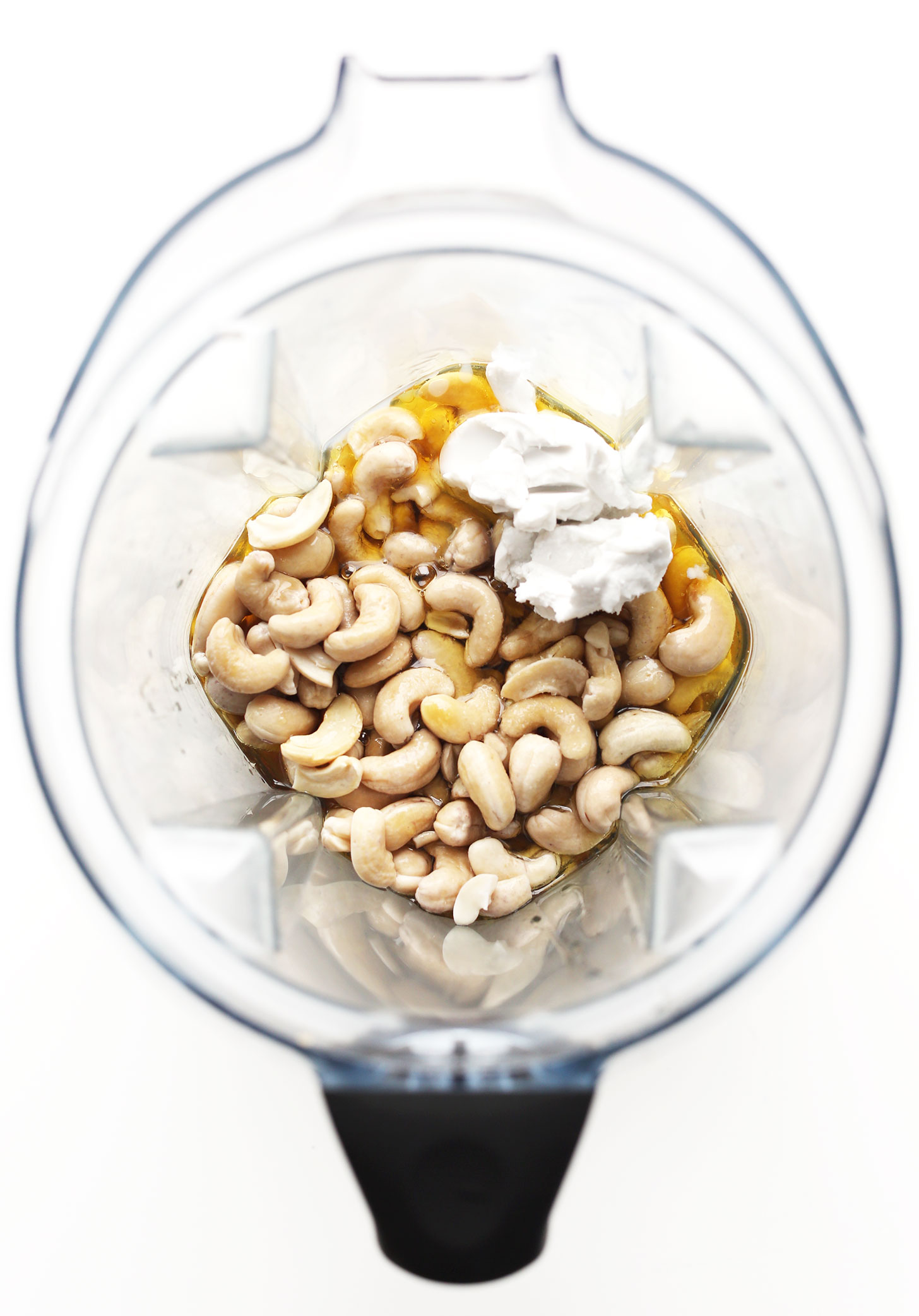 Blender with ingredients for making gluten-free vegan White Chocolate Cheesecake