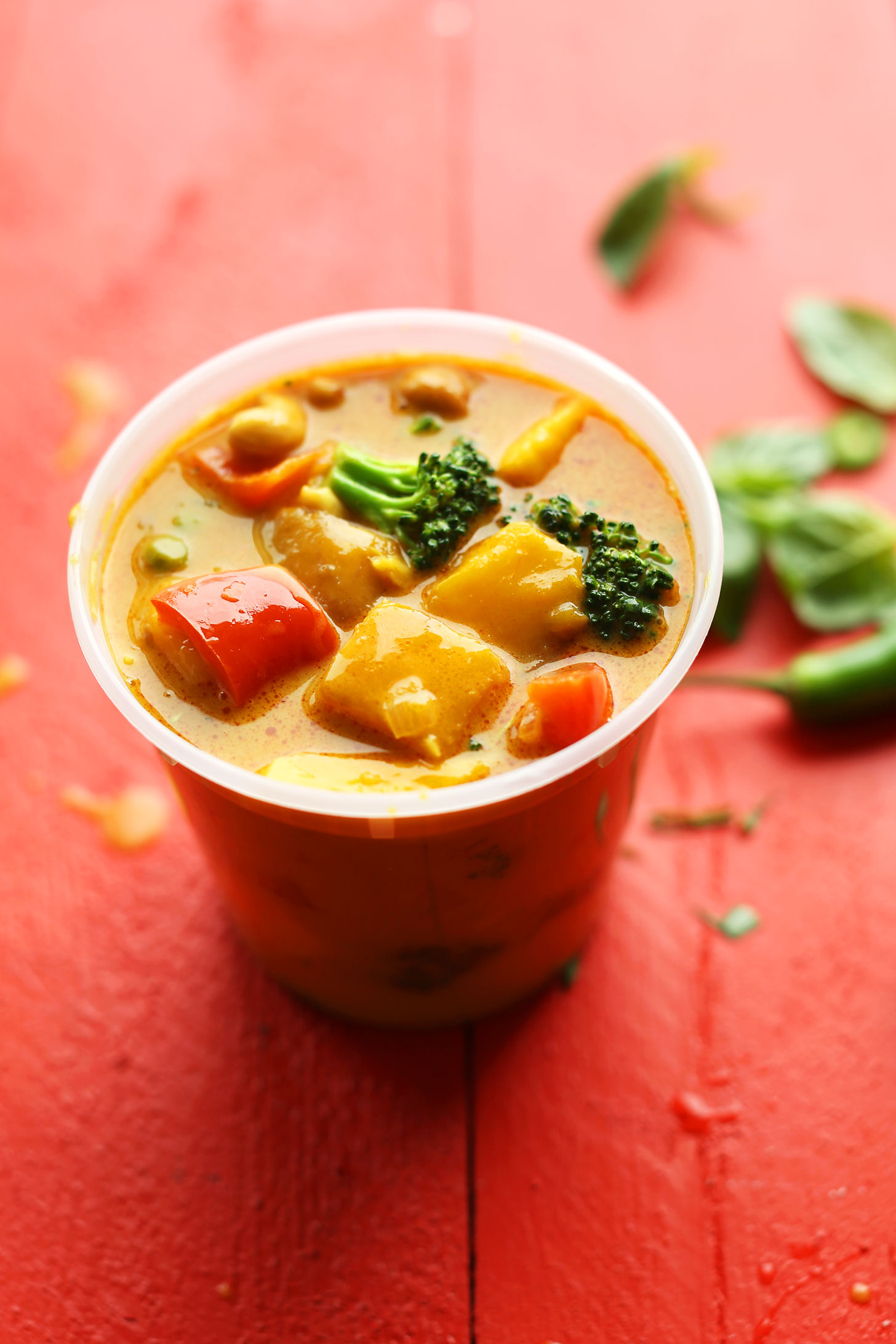 Takeout container filled with our gluten-free vegan Thai Curry with Mango, Red Pepper and Cashews