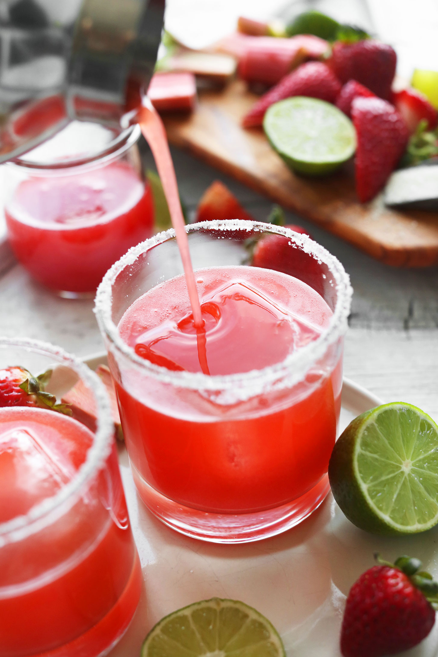 Pouring our gluten-free vegan Strawberry Rhubarb Margarita recipe into a glass