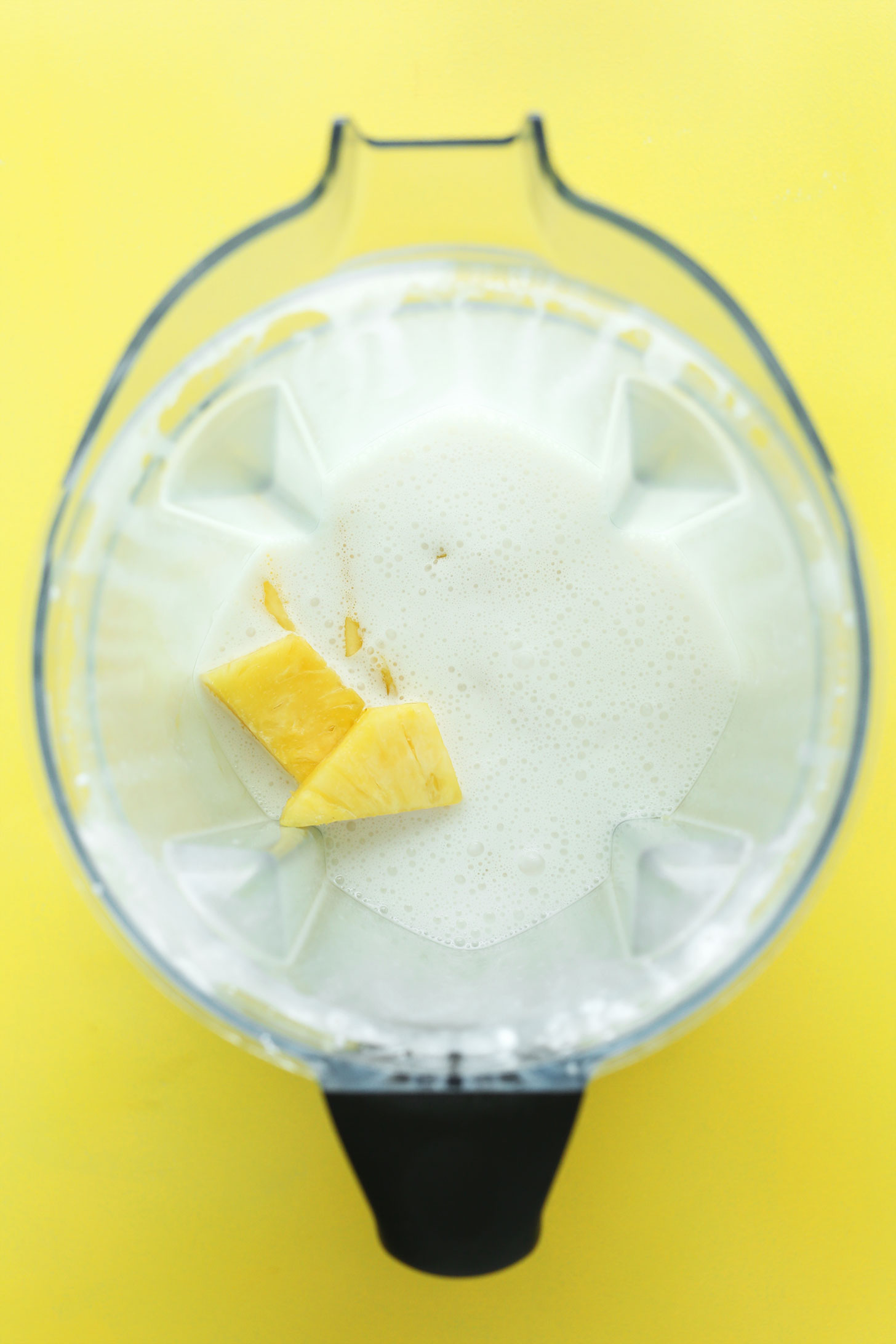 Blender with ingredients for making Pina Colada Popsicles for a refreshing vegan treat
