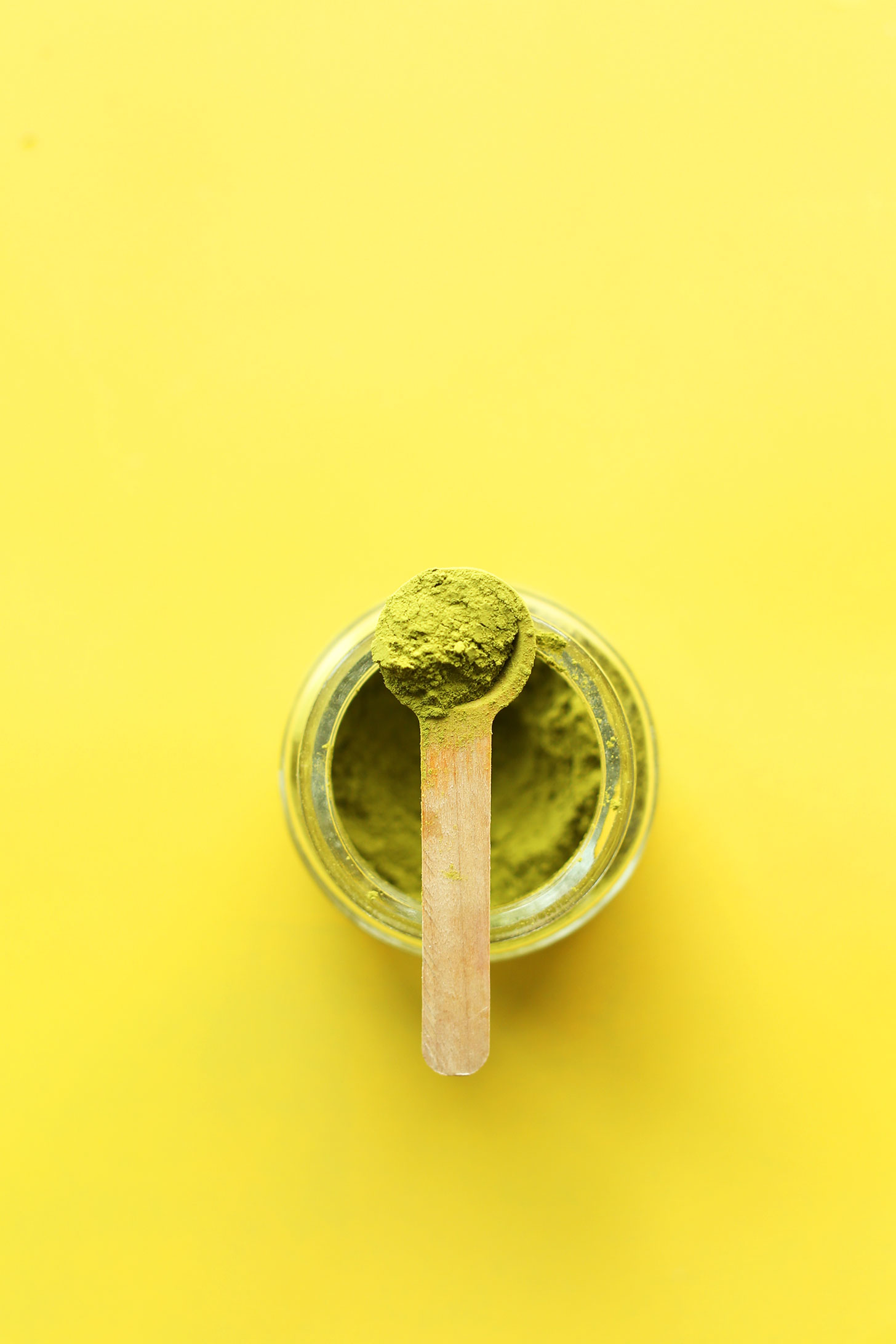 Small scoop of matcha resting on a jar