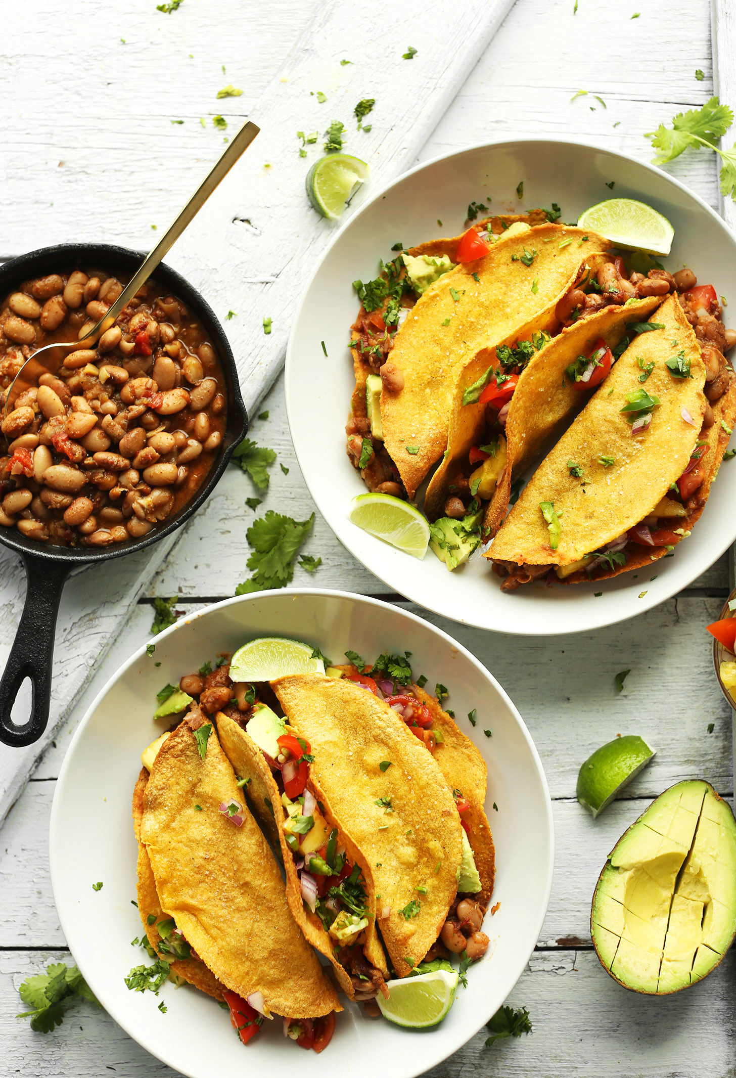 Two big bowls of homemade Crispy Baked Corn Tacos with Pinto Beans, Pineapple Salsa, and Avocado