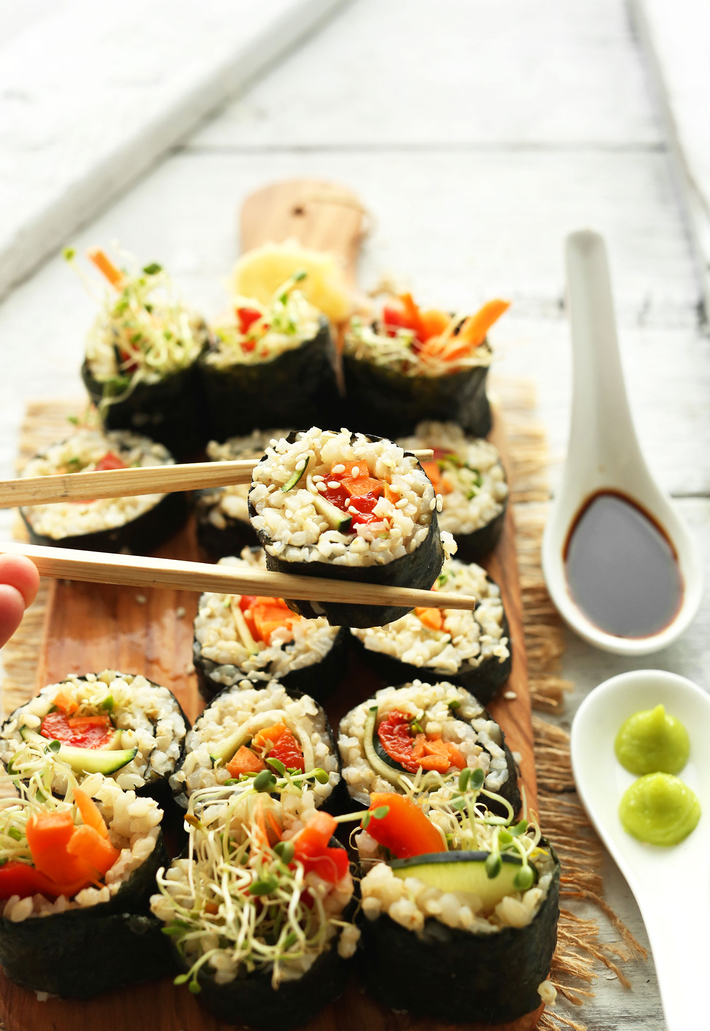 Using chopsticks to pick up a roll of our Vegan Brown Rice Sushi