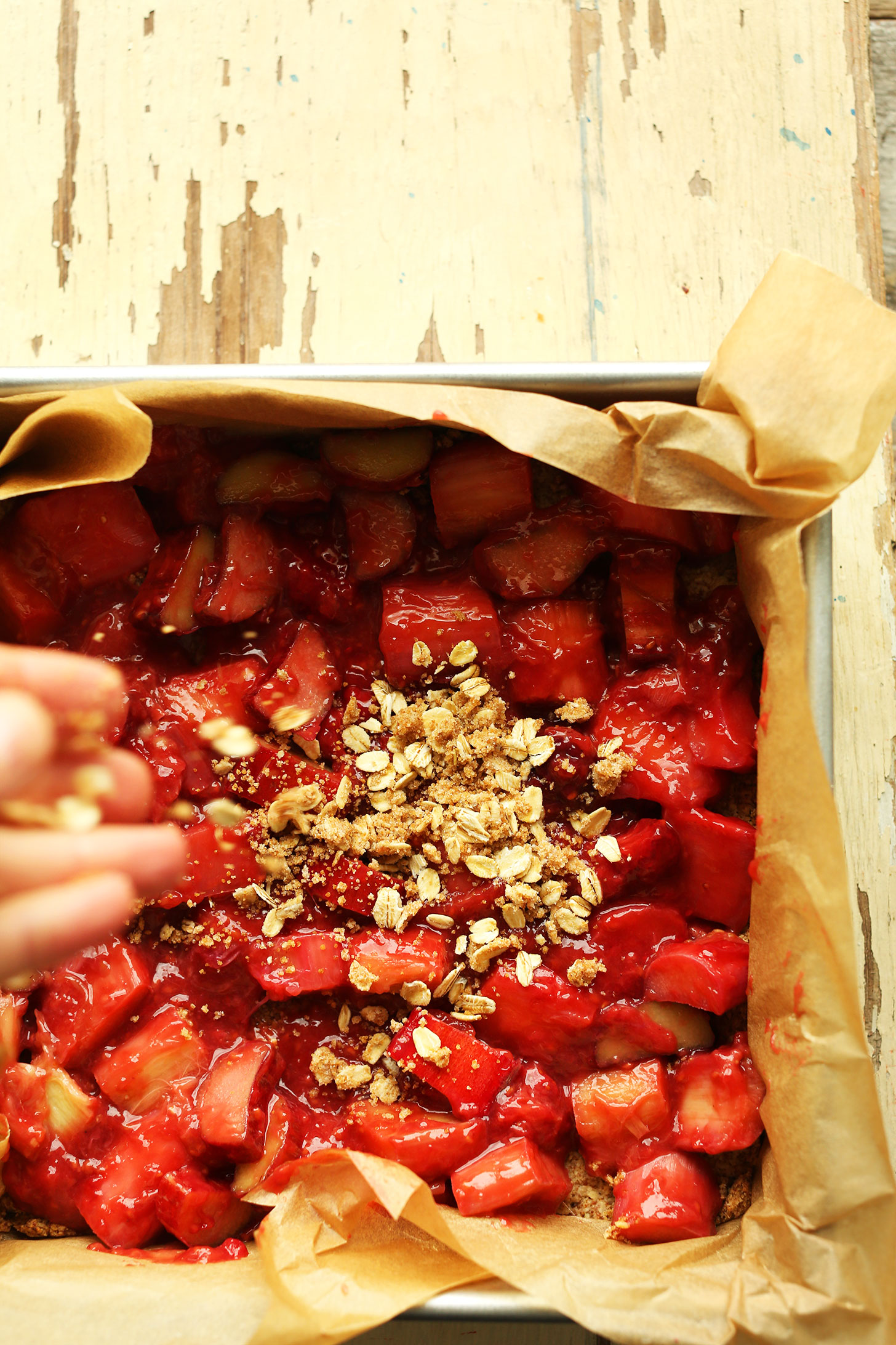 Sprinkle crumble topping onto our gluten-free vegan Strawberry Rhubarb Bars