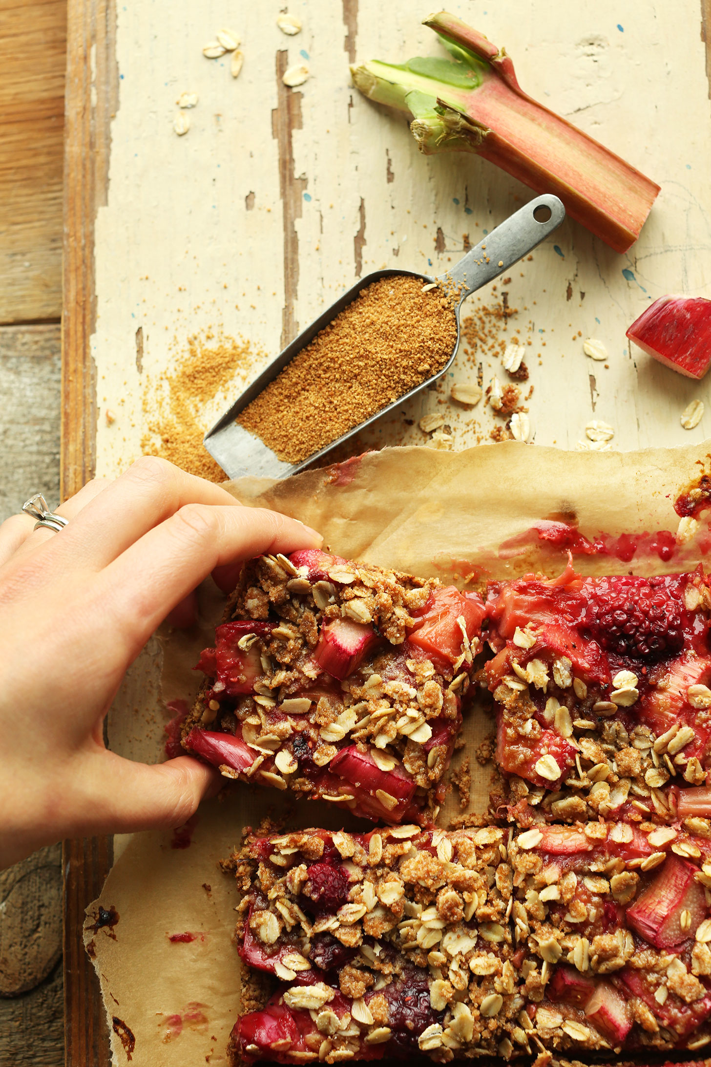 Grabbing a square of our Strawberry Rhubarb Crumble Bars recipe from the batch