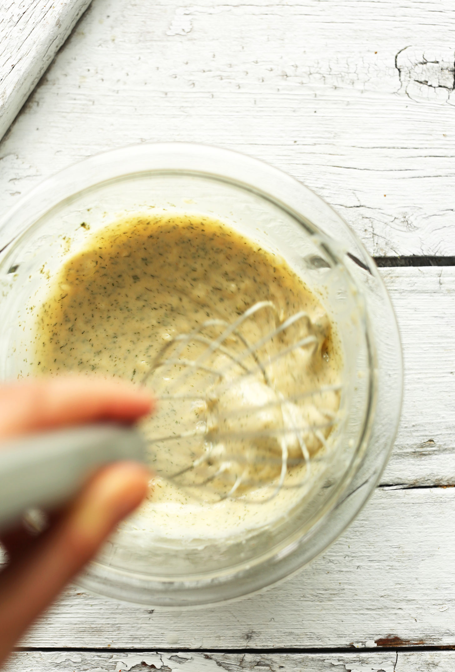 Whisking together ingredients for garlic herb sauce for our Chickpea Shawarma Dip recipe