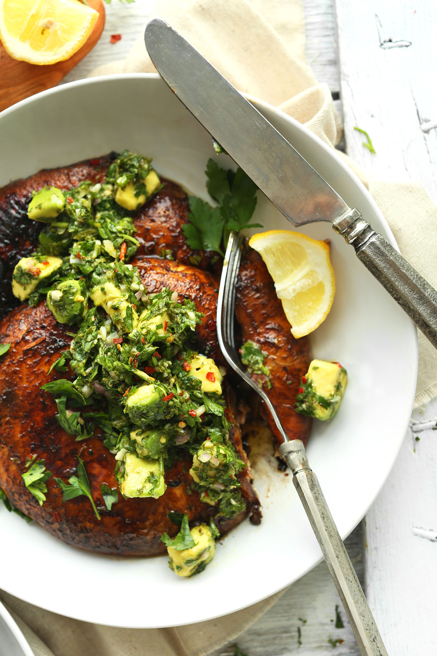 Using a fork to cut into a Grilled Portobello Steak with Avocado Chimichurri