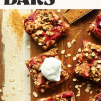Overhead photo of Strawberry Rhubarb Crumble Bars on a wood board with text above the photo that says vegan and gluten-free