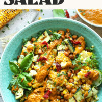 Overhead photo of a bowl of our Grilled Corn & Zucchini Salad with text that says with sun-dried tomato vinaigrette