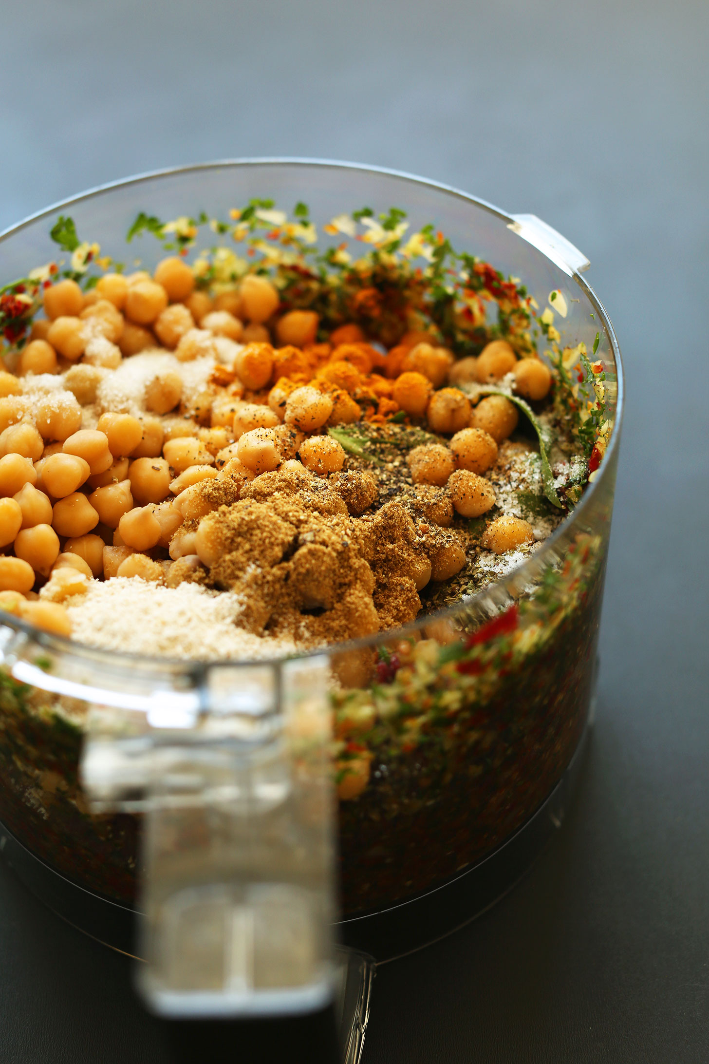 Food processor with ingredients for our gluten-free vegan Sun-Dried Tomato Herbed Veggie Burgers
