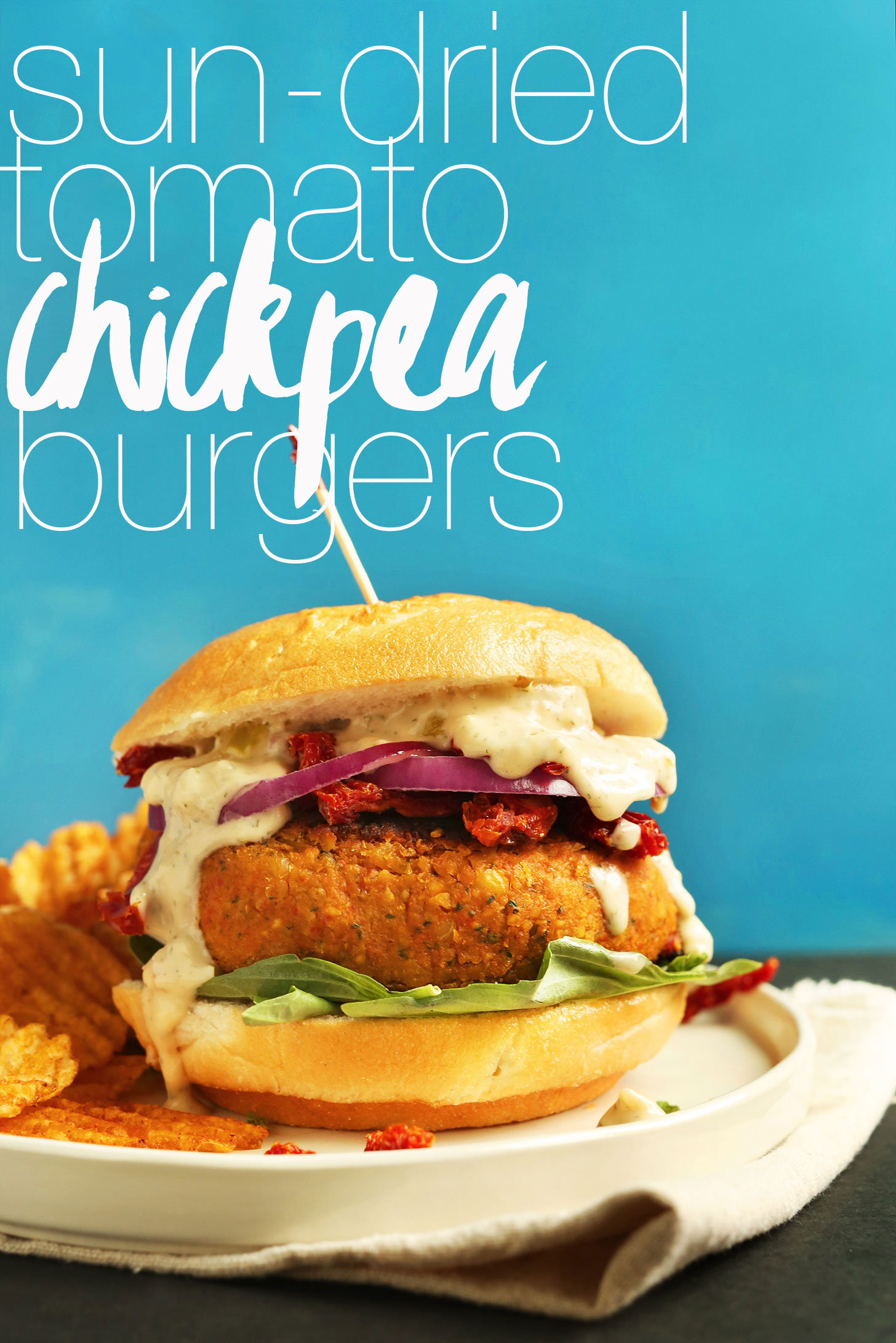 Sun-dried Tomato Herbed Chickpea Burger served on a plate with chips