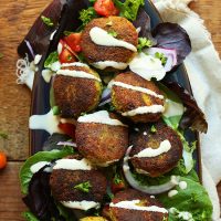 Tray of salad topped with Classic Vegan Falafel and tahini sauce