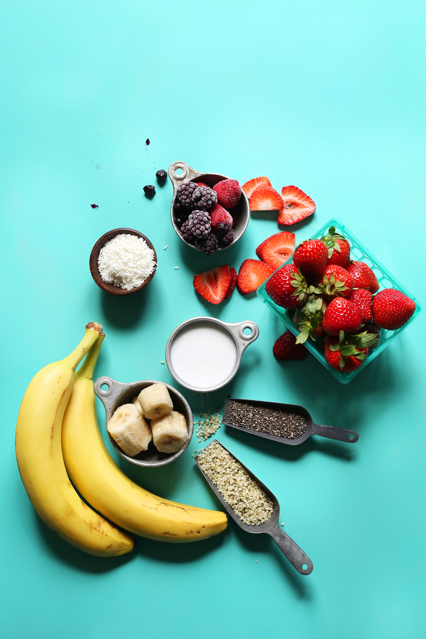 Bananas, berries, coconut, nut milk, chia seeds, and hemp seeds for making my go-to vegan smoothie bowl recipe