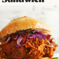 Vegan pulled pork sandwich resting on a cutting board
