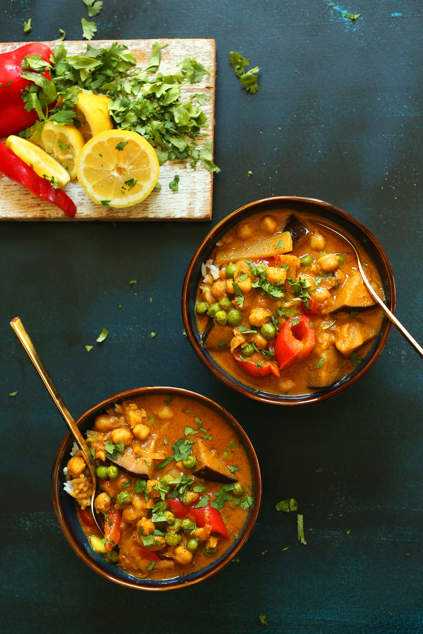 Two bowls of our gluten-free plant based Chickpea Red Curry alongside ingredients to make it