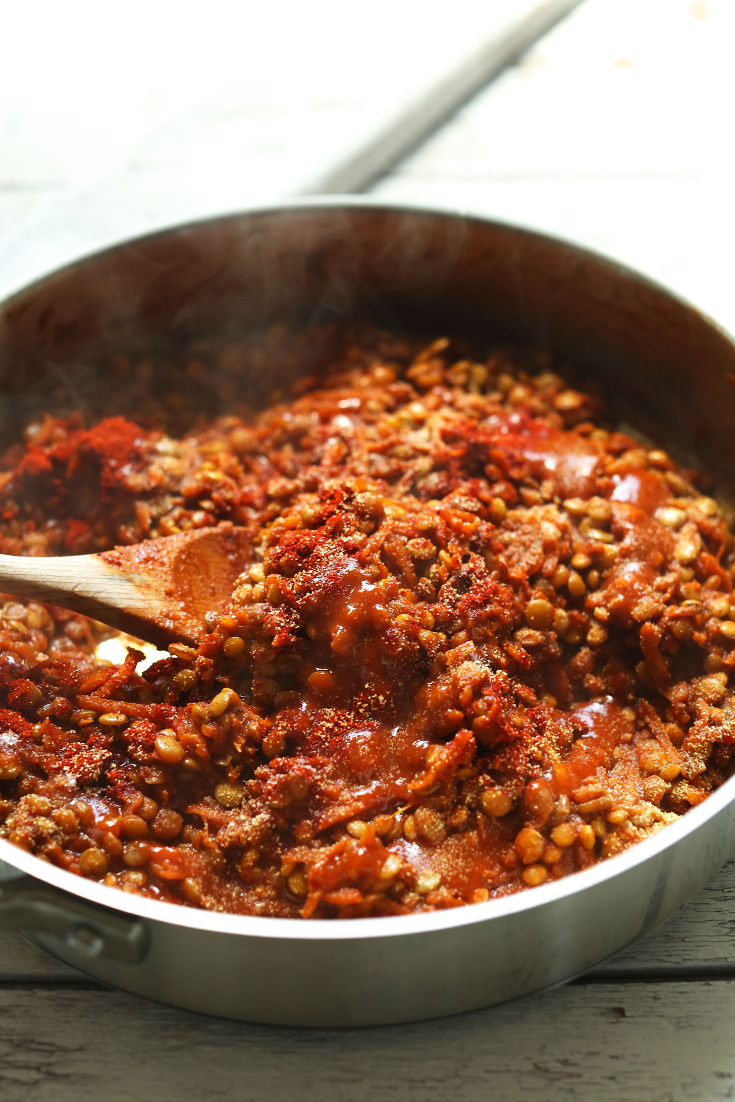 Using a wooden spoon to stir filling for Lentil Vegan Pulled Pork Sandwiches