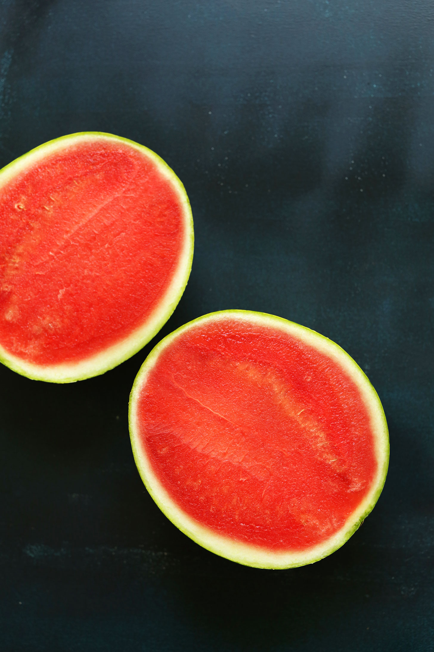 Halved fresh watermelon for making vegan Watermelon Sashimi