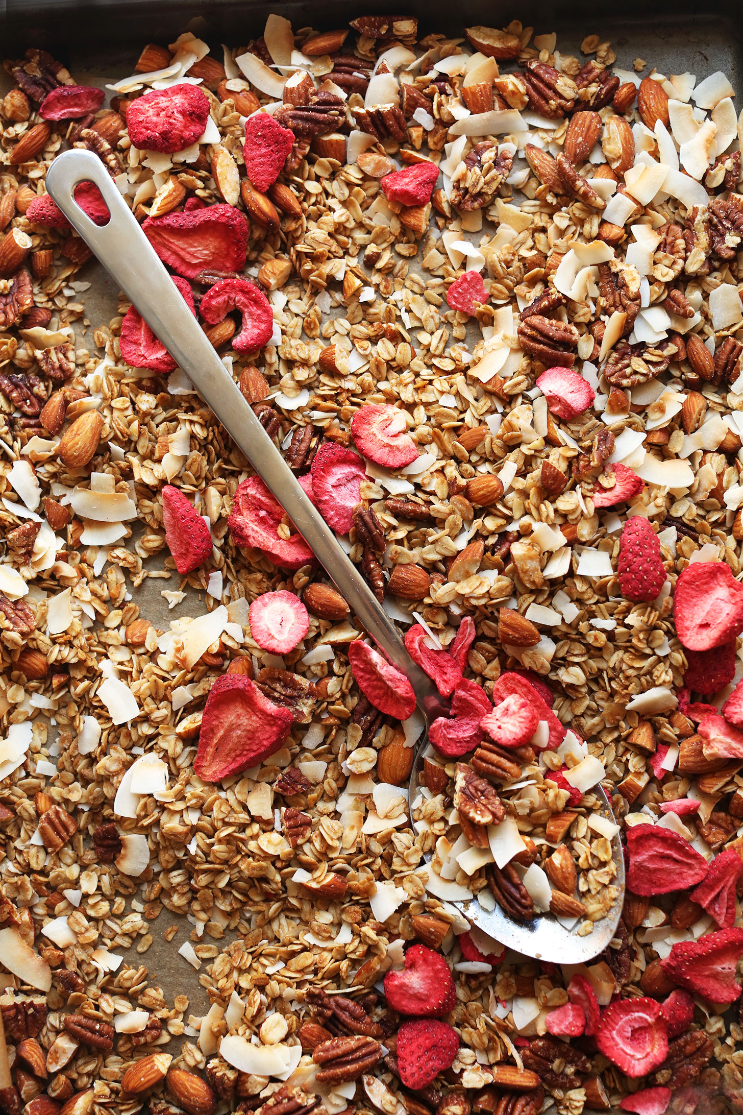 Parchment-lined baking sheet with our gluten-free vegan Coconut Strawberry Granola recipe