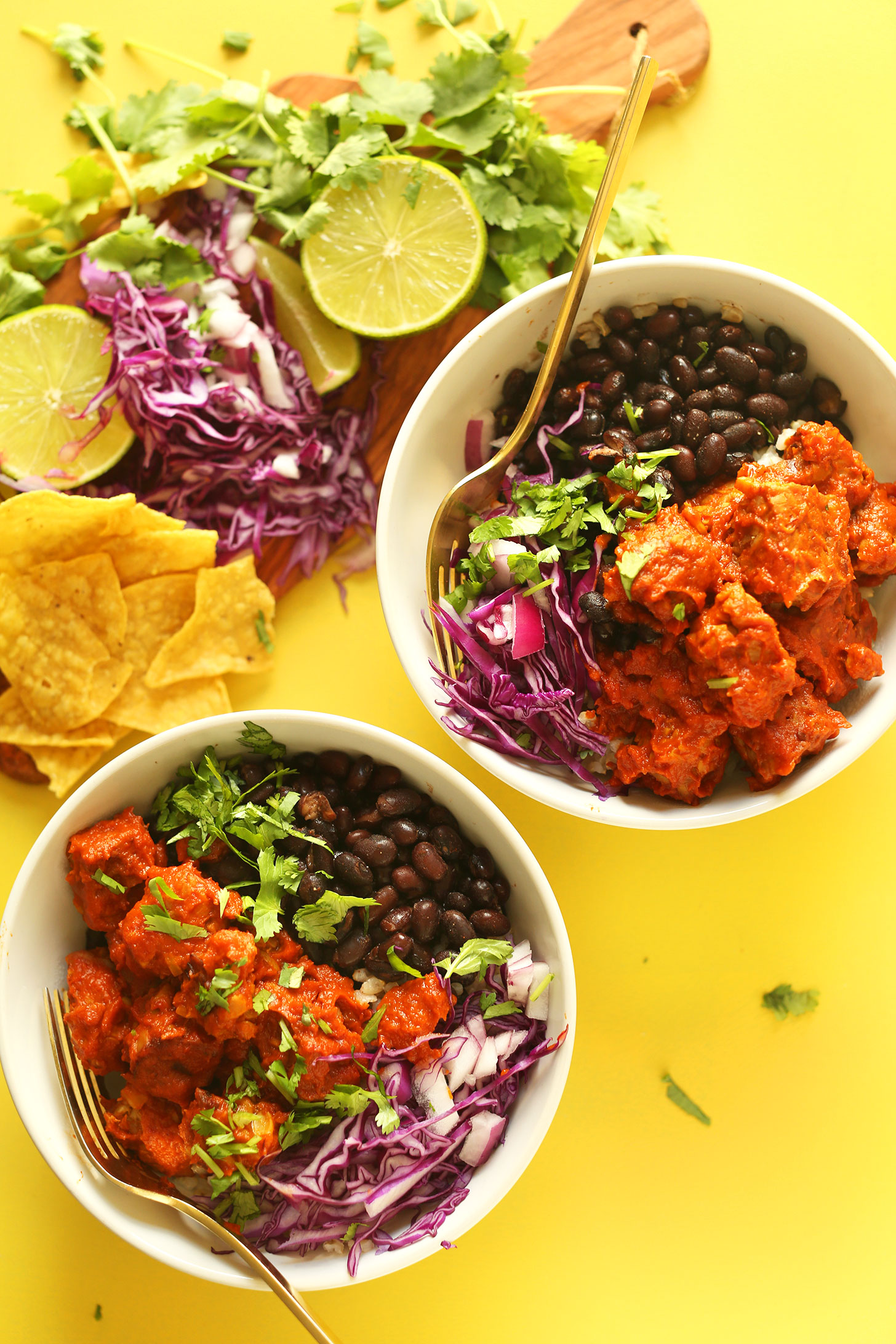 Two servings of our Smoky Tempeh Burrito Bowls recipe alongside ingredients used to make it