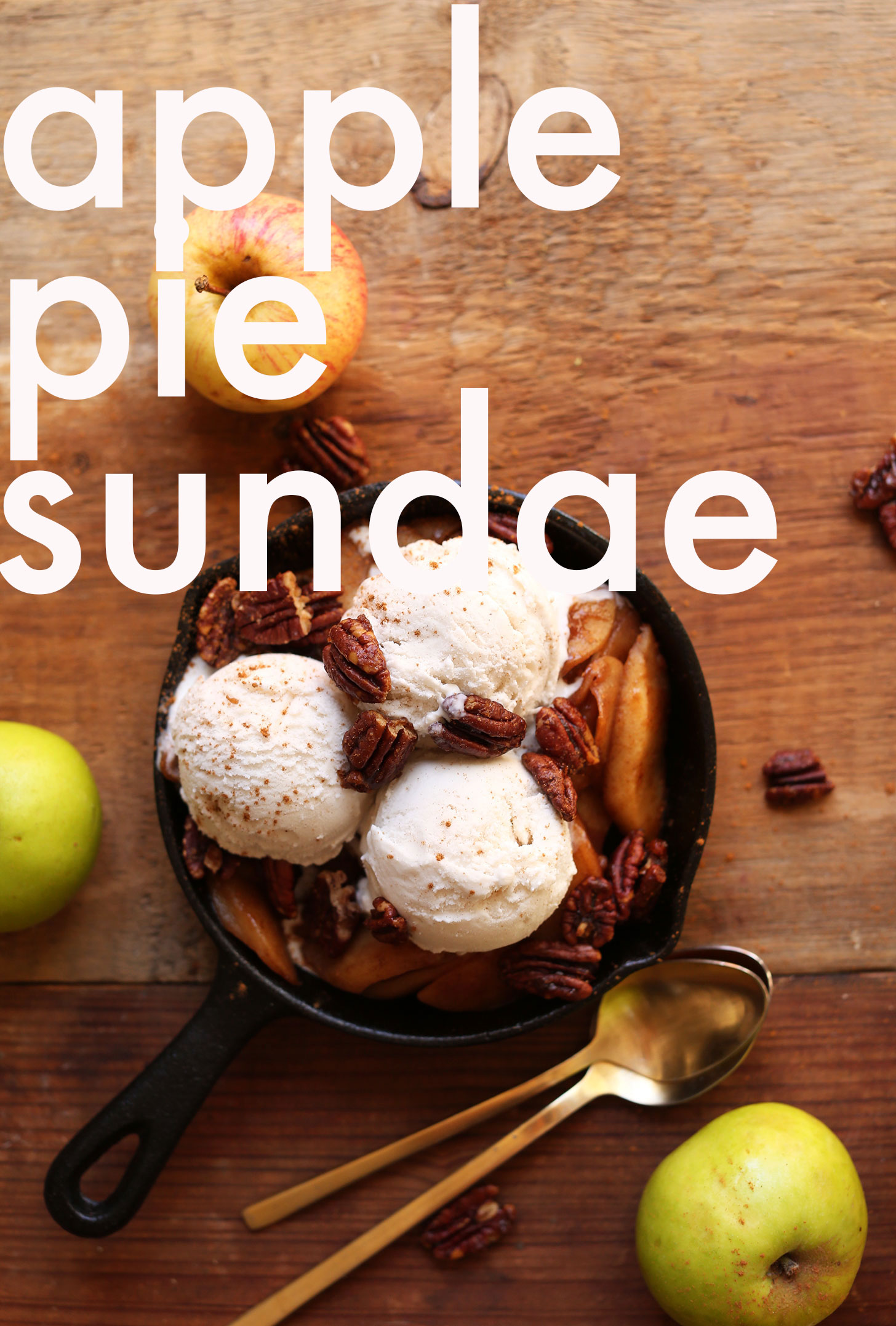 Mini cast-iron skillet with cooked cinnamon apples, vegan vanilla ice cream, and toasty pecans