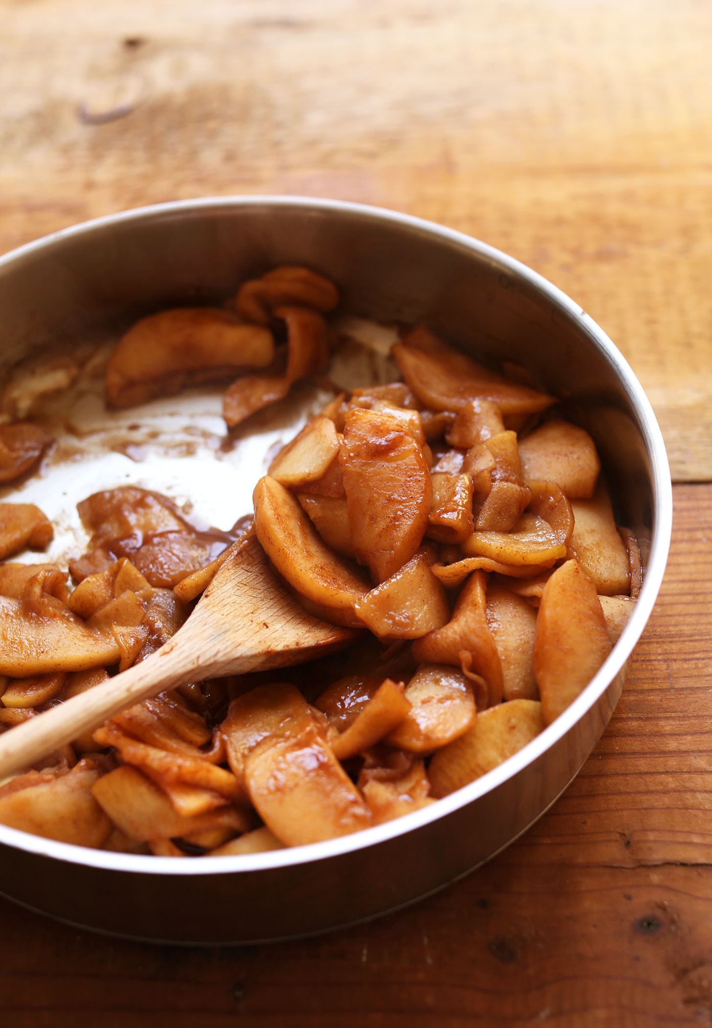 Cooked sliced apples and melted vegan ice cream in a large skillet