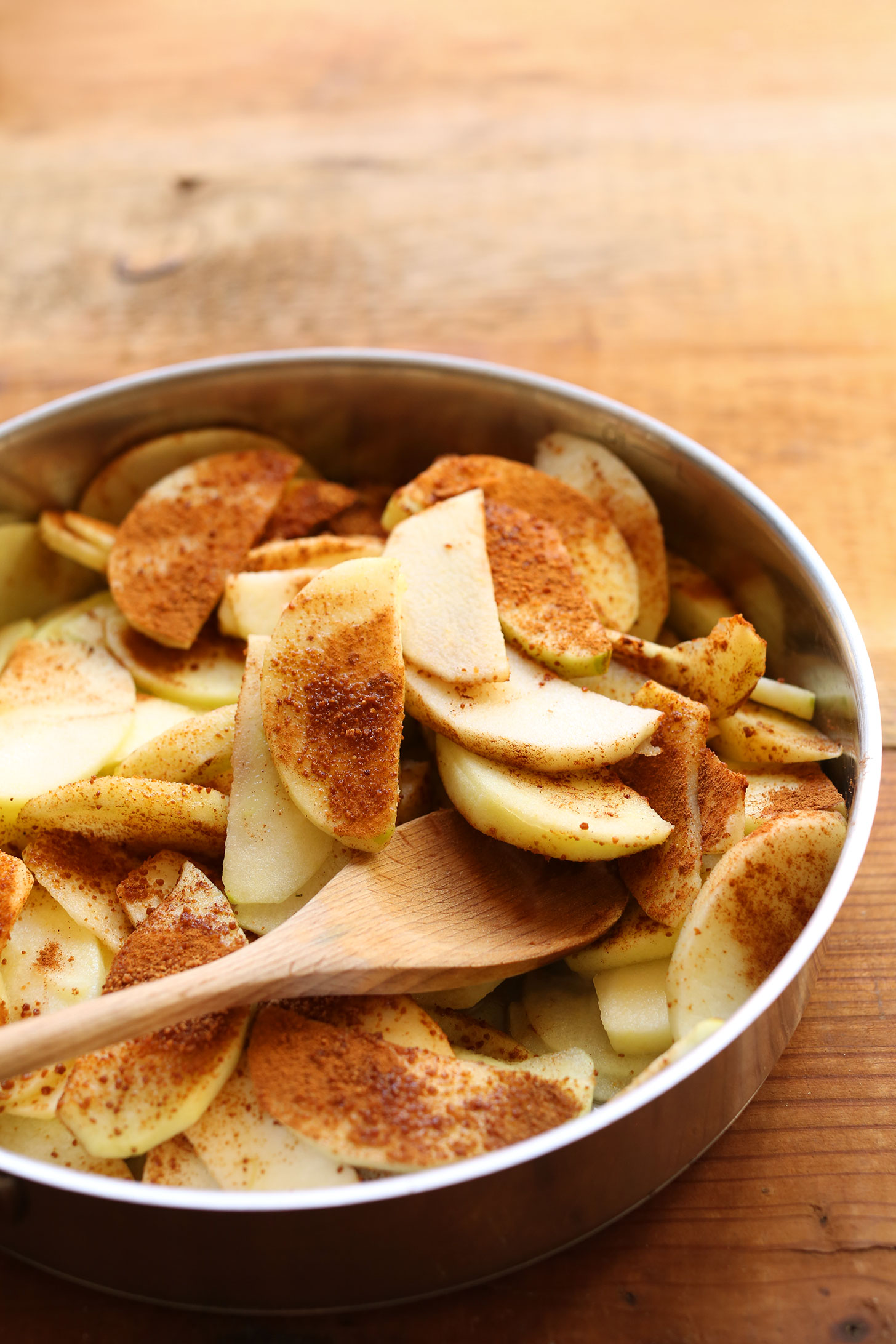 Stirring together a skillet with sliced apples and cinnamon