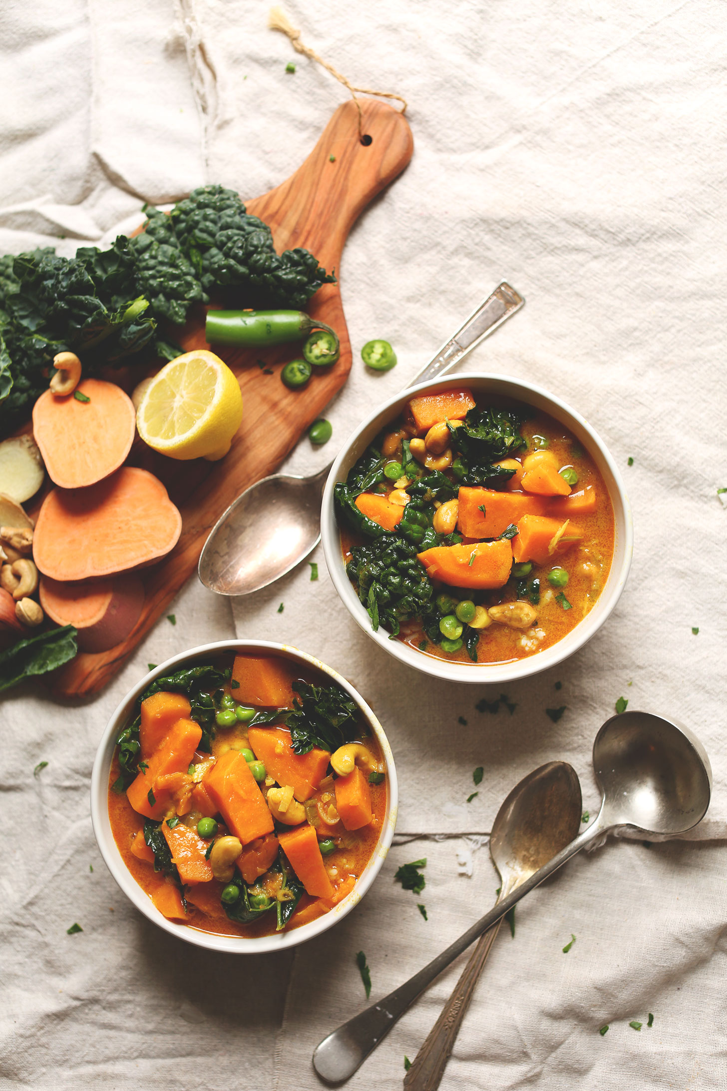 Two big bowls of our Sweet Potato Kale Curry recipe alongside ingredients used to make it