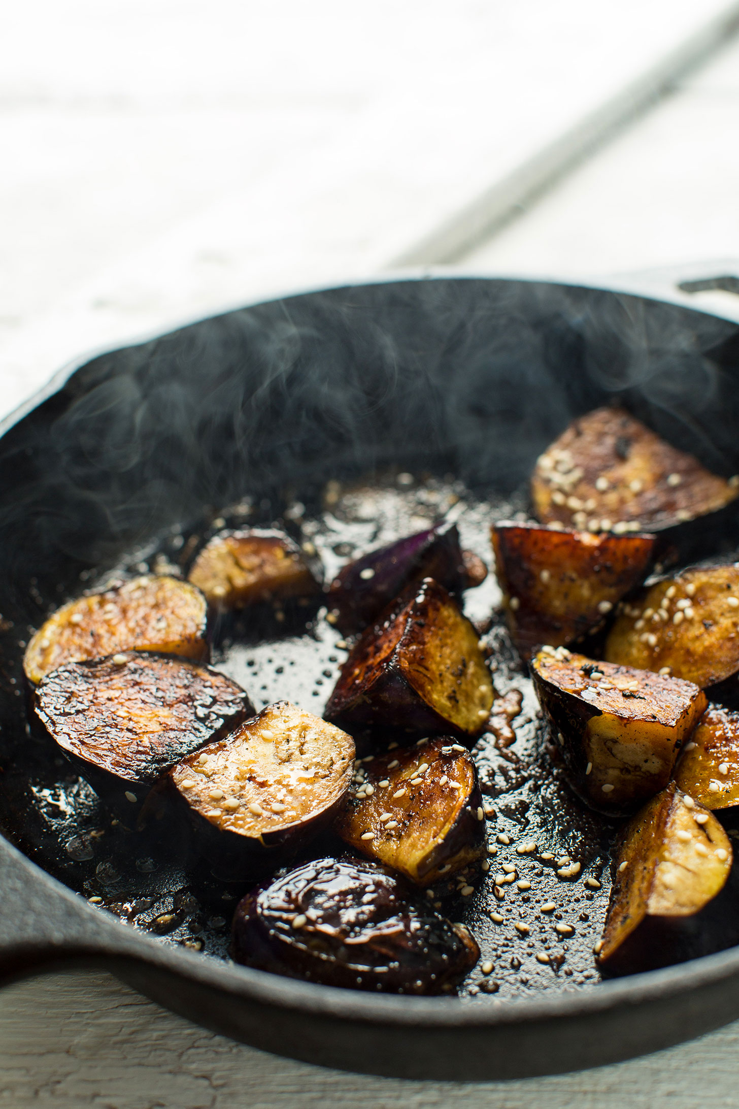 Cooking eggplant in a cast-iron skillet for a delicious gluten-free vegan meal