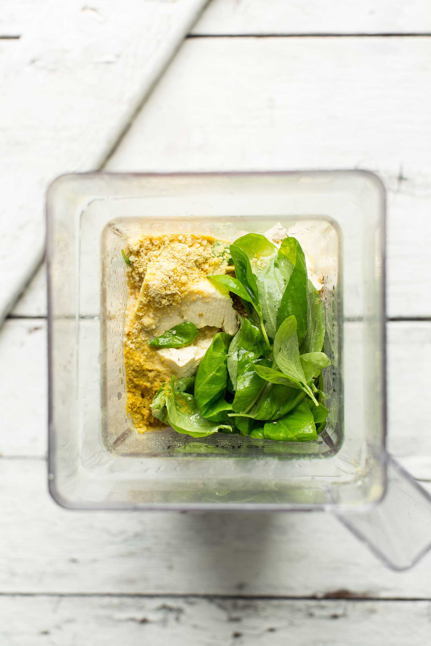 Blender with ingredients for making vegan cheese filling for lasagna