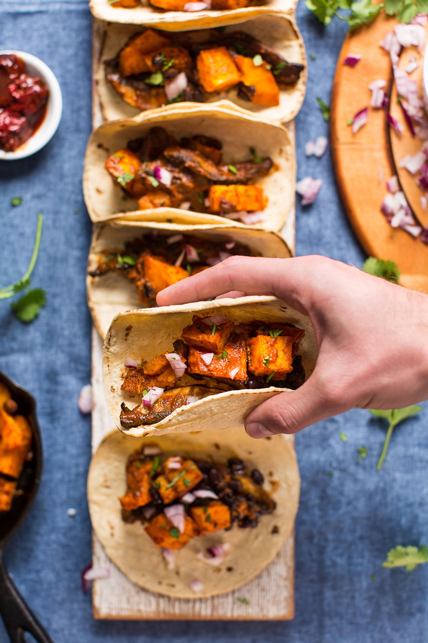 Holding up a Saucy Butternut Squash and Portobello Taco for a healthy gluten-free plant-based meal