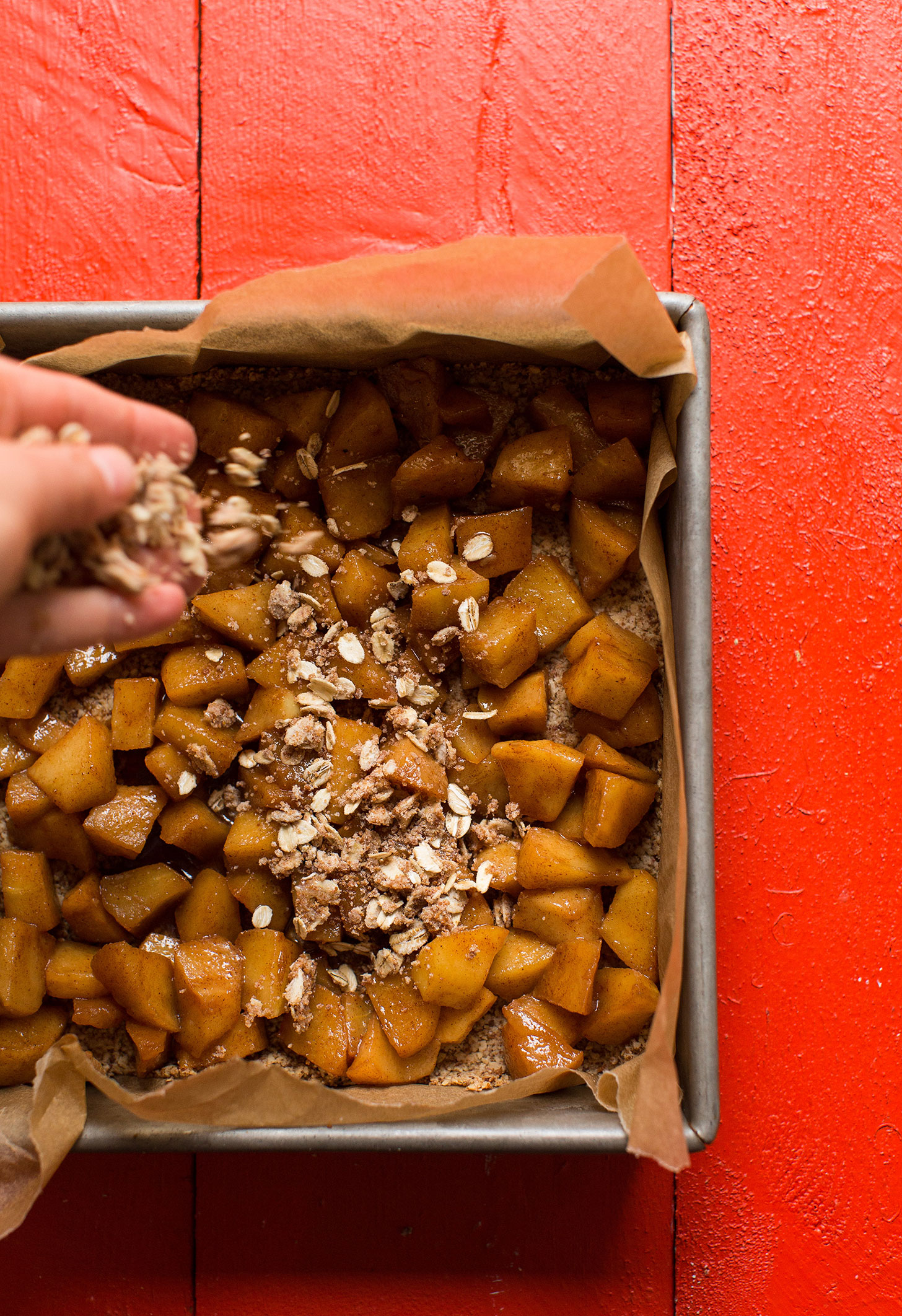 Sprinkling delicious gluten-free crumble topping onto our vegan apple pie bars recipe