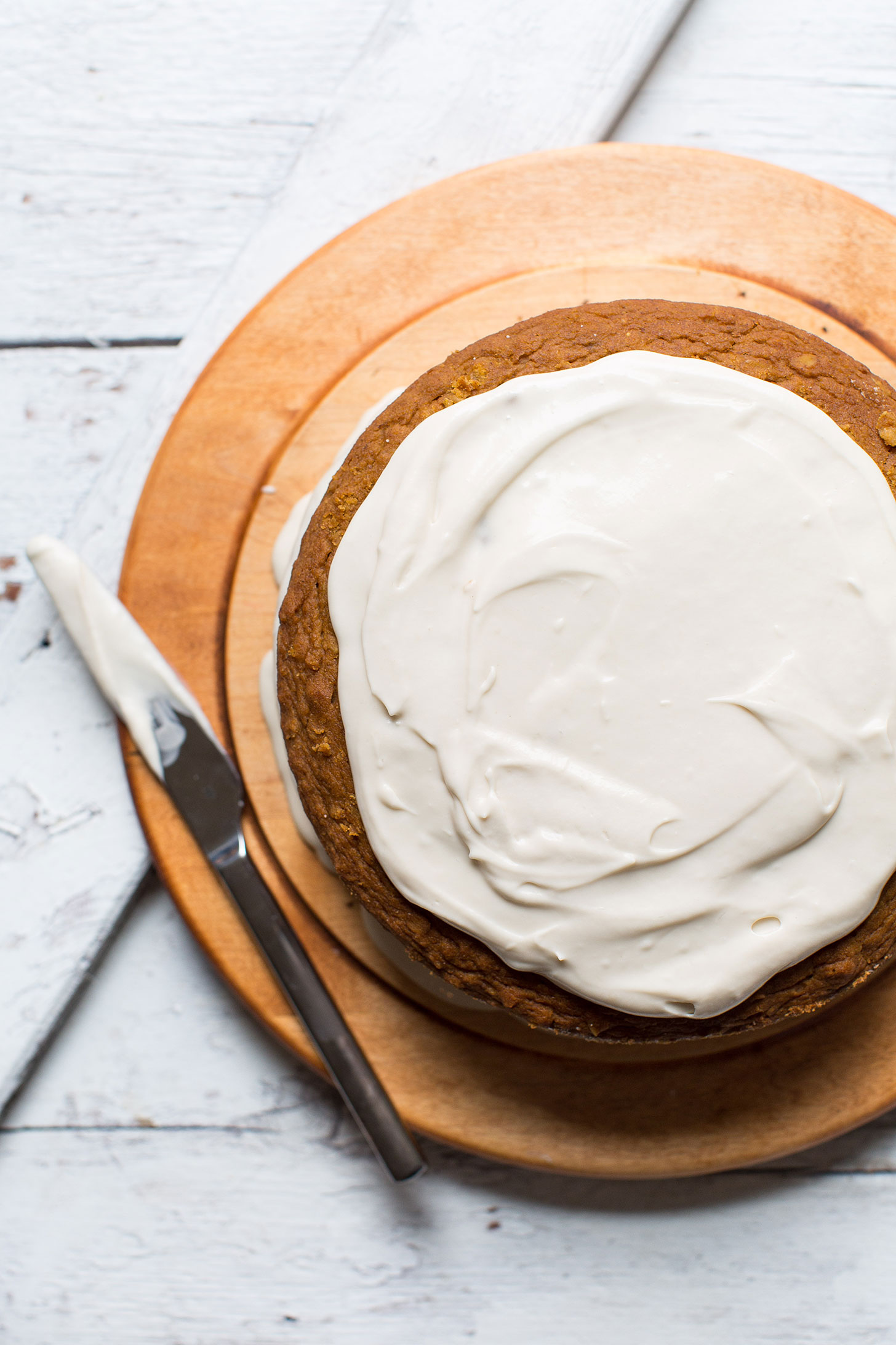 Spreading homemade vegan frosting onto our gluten-free Pumpkin Cake