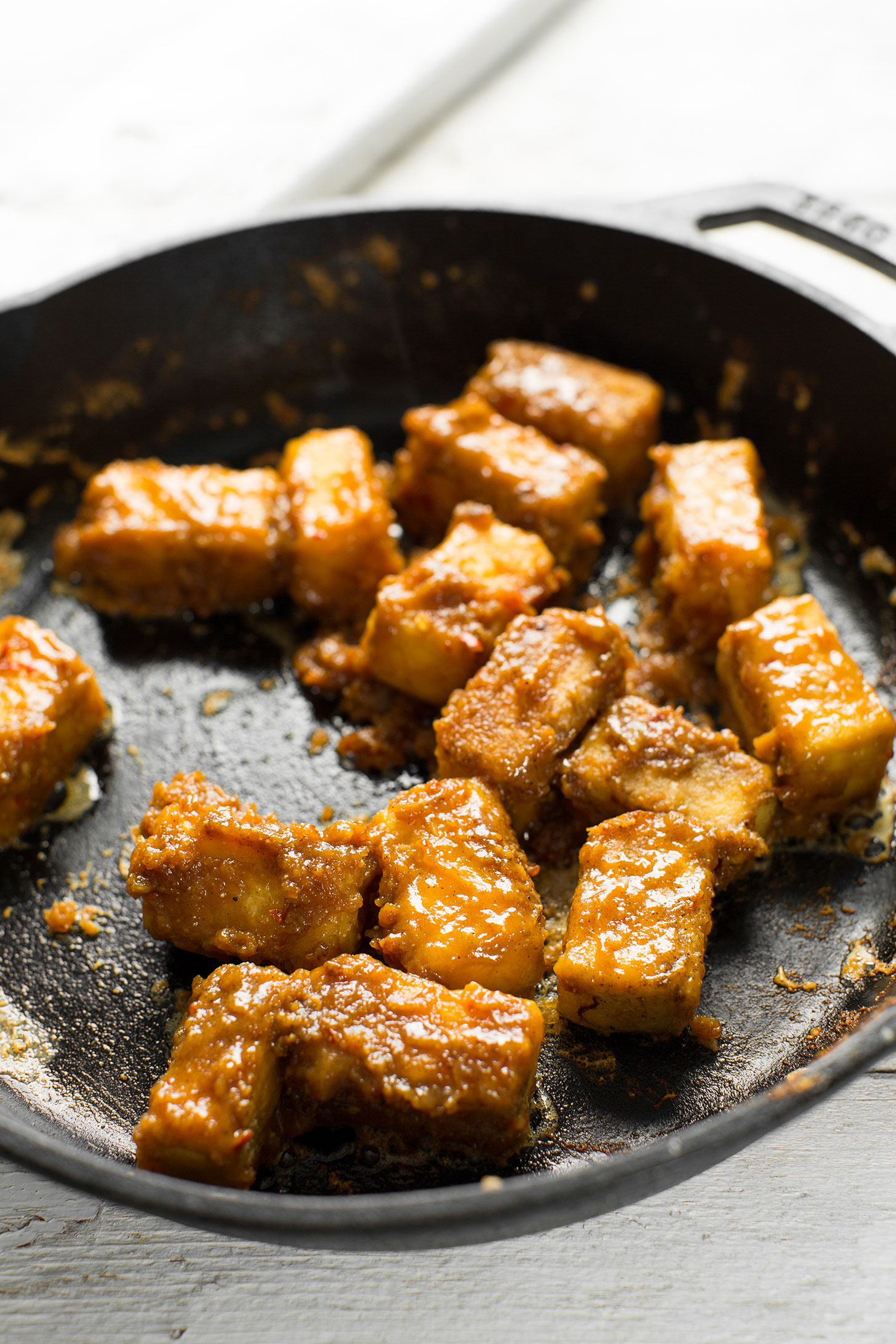 Cooking Almond Butter Tofu in a cast-iron skillet for a protein-packed plant-based meal