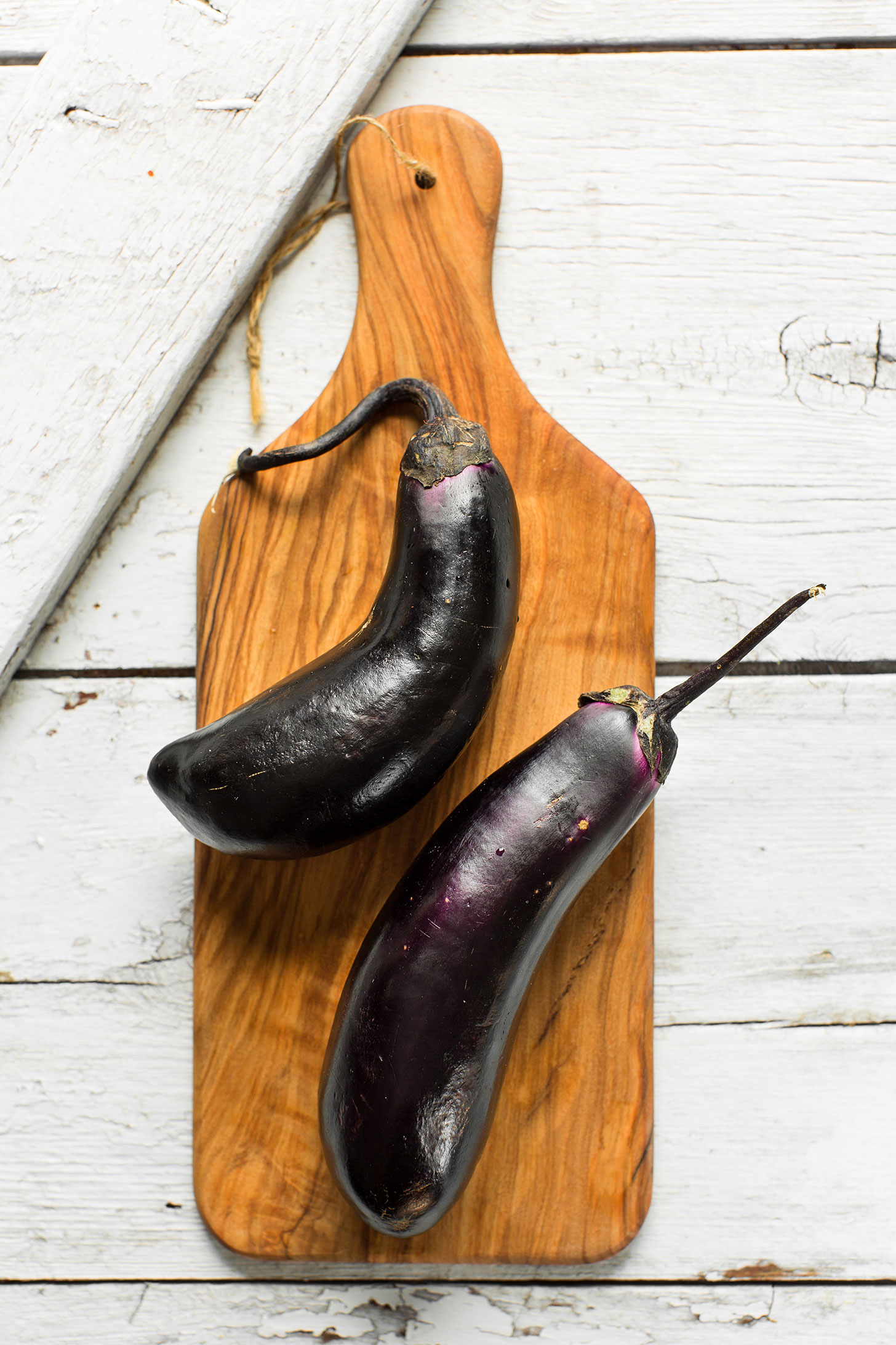 Fresh eggplants on a cutting board ready to be made into Sesame Stir-Fried Eggplant