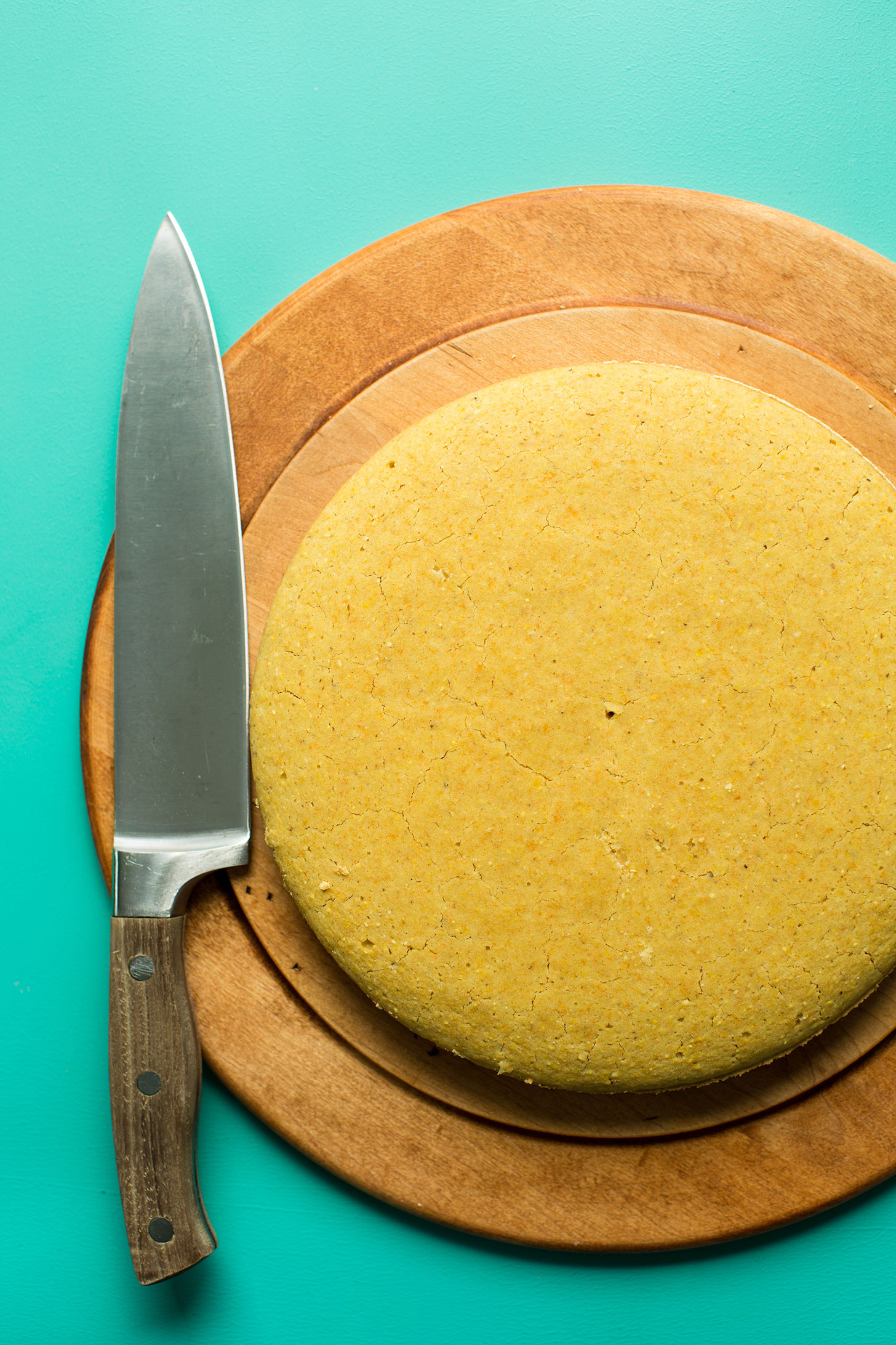 Wood cutting board with perfect gluten-free vegan cornbread ready for cutting