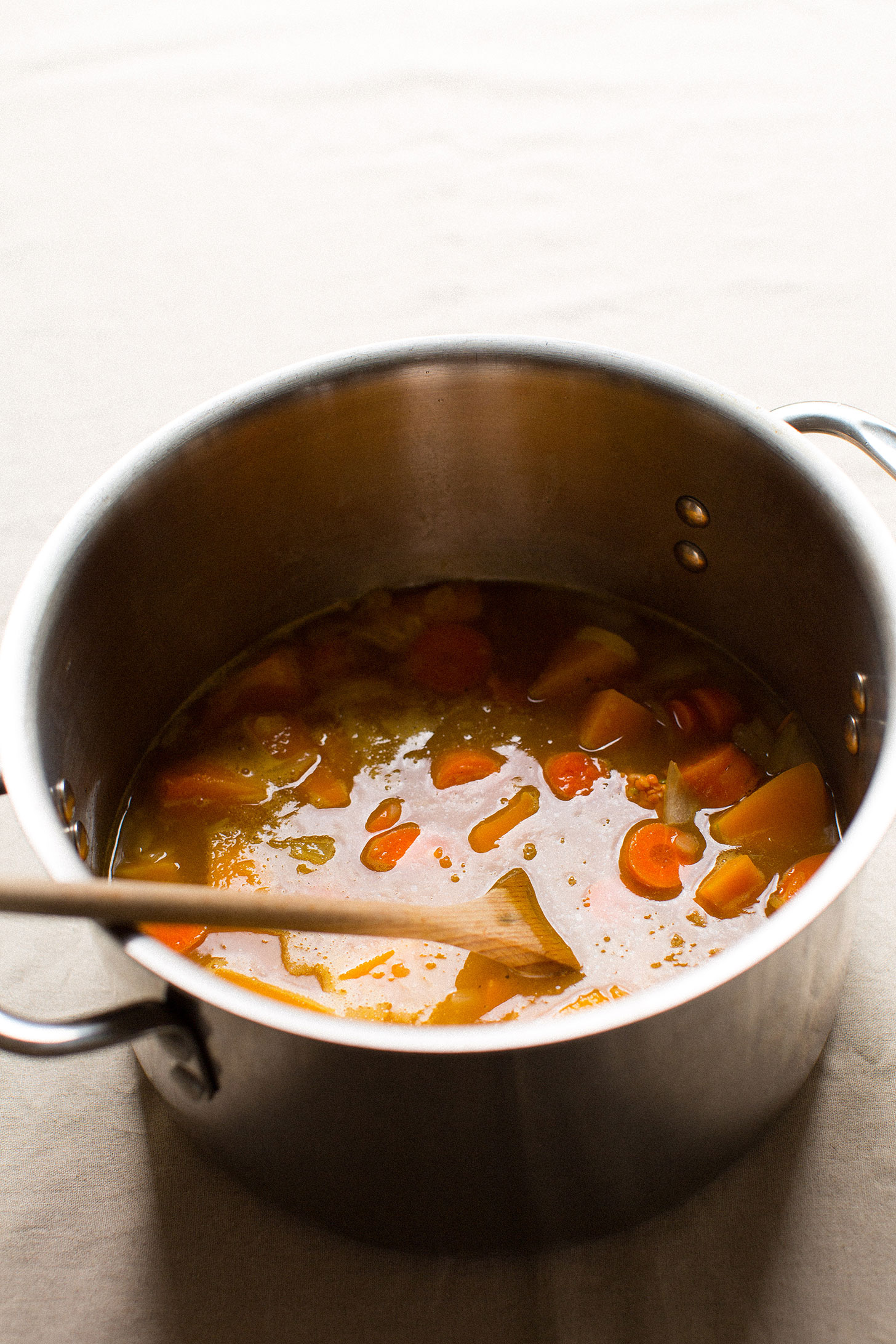 Soup pot filled with ingredients for making gluten-free vegan Acorn Squash Soup for Thanksgiving