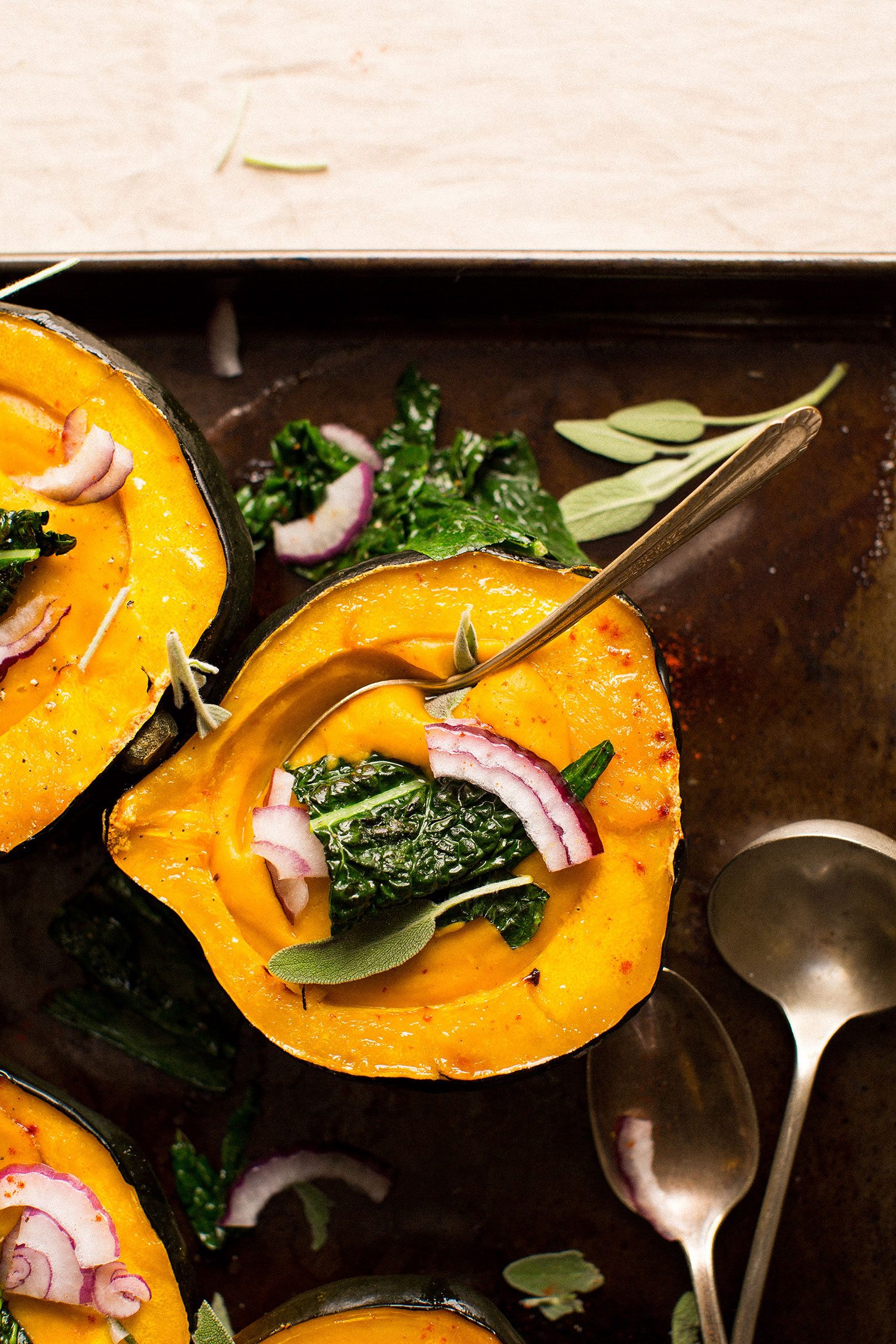 Grabbing a spoonful of gluten-free vegan Acorn Squash Soup from a squash bowl