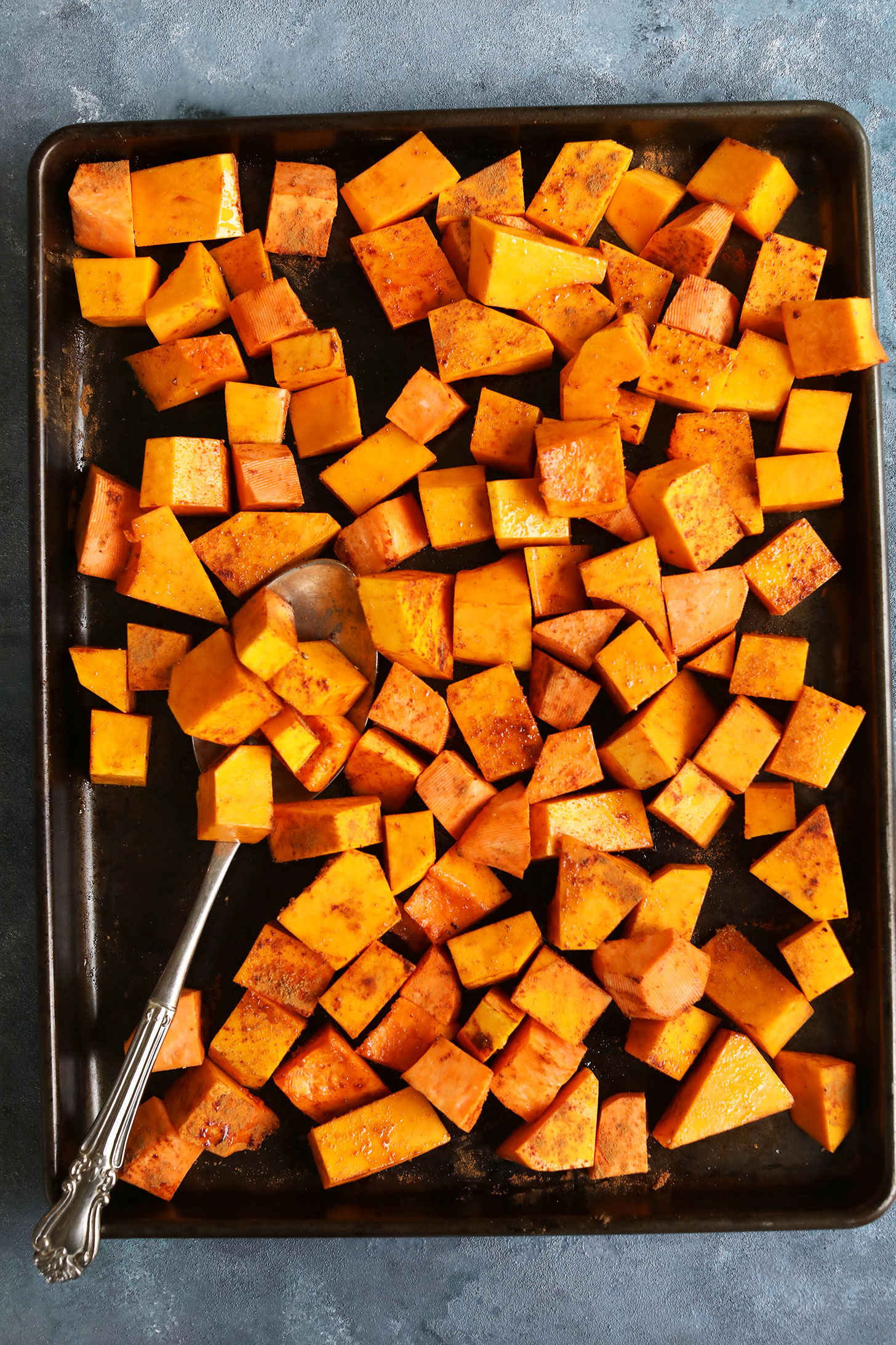 Baking sheet with cubed butternut squash for making a gluten-free vegan thanksgiving salad recipe