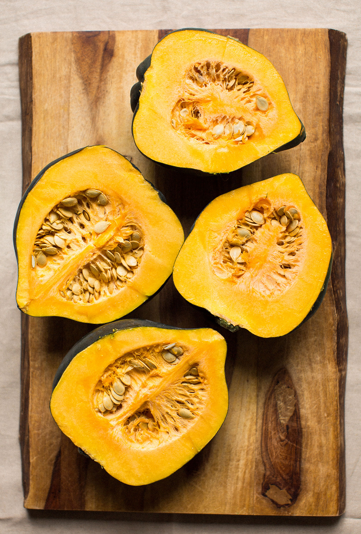 Fresh halved acorn squashes ready to have their seeds removed