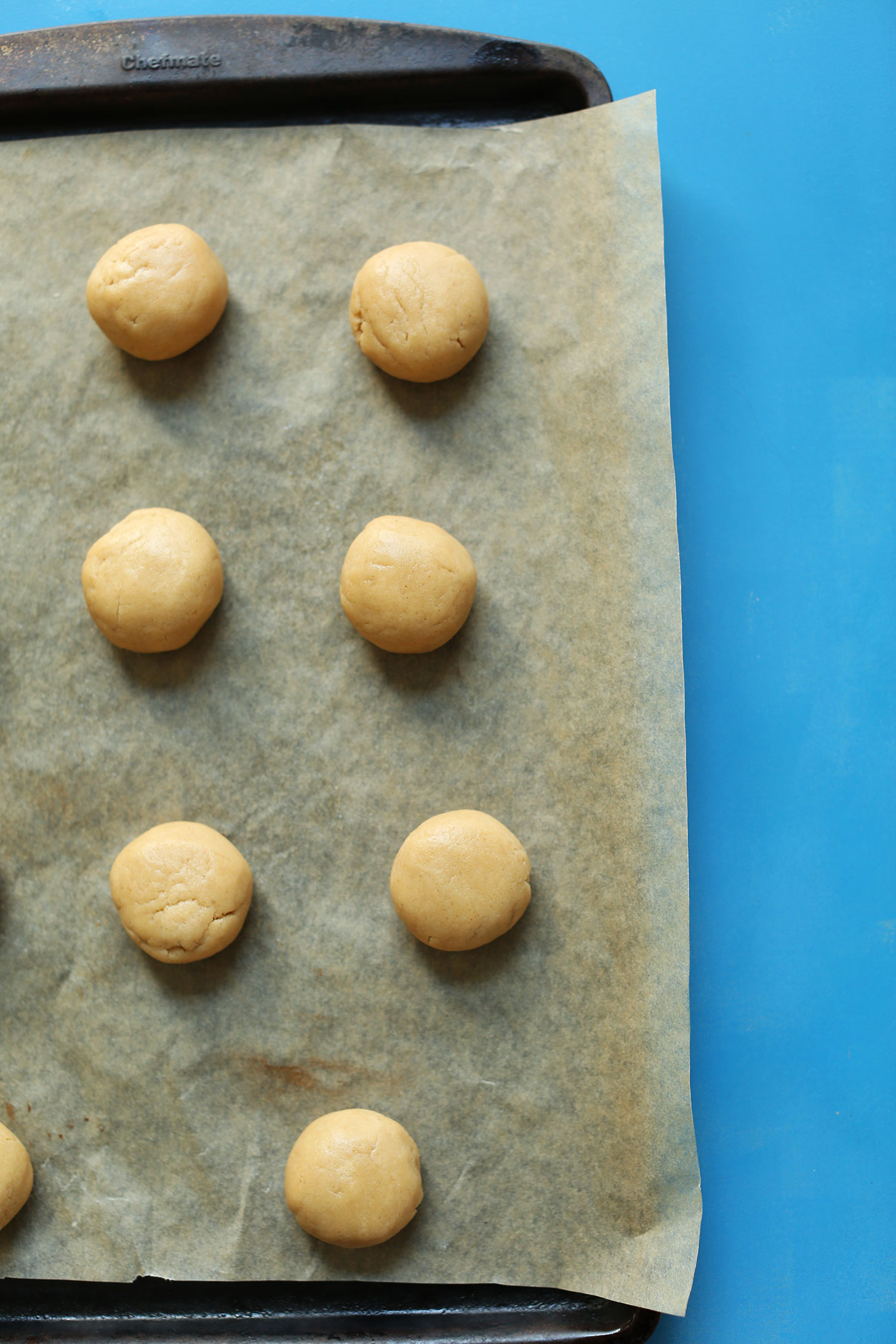 Parchment-lined baking sheet filled with peanut butter cup cookies ready for baking