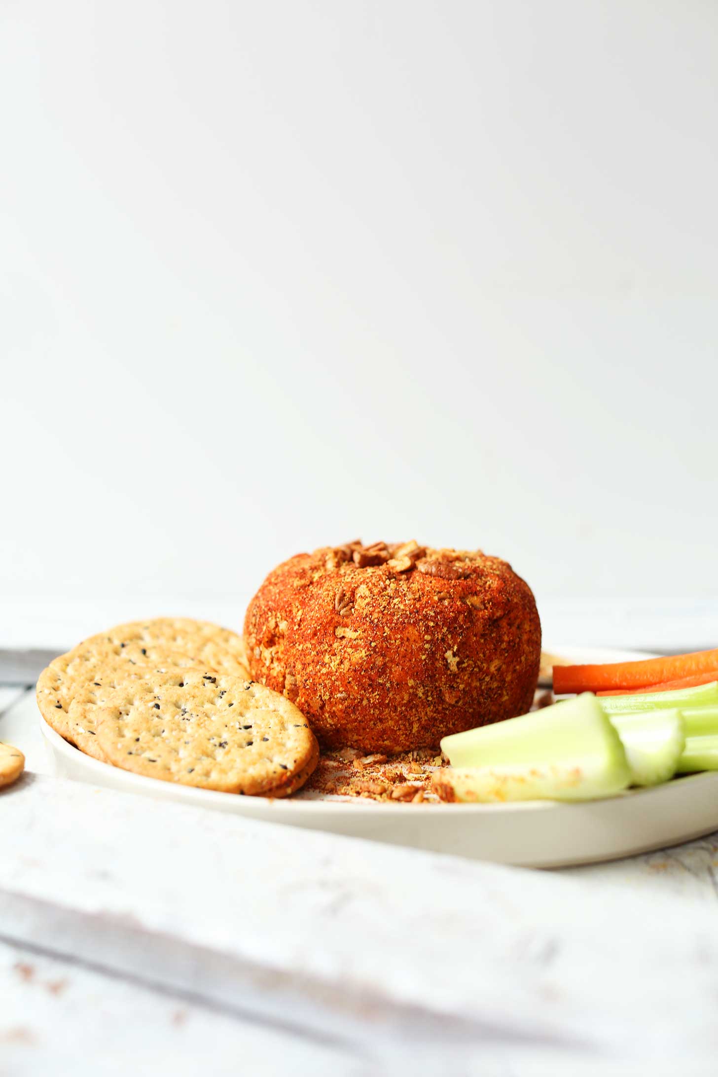 Crackers, veggie sticks, and a Spicy Vegan Cheese Ball for the perfect holiday appetizer