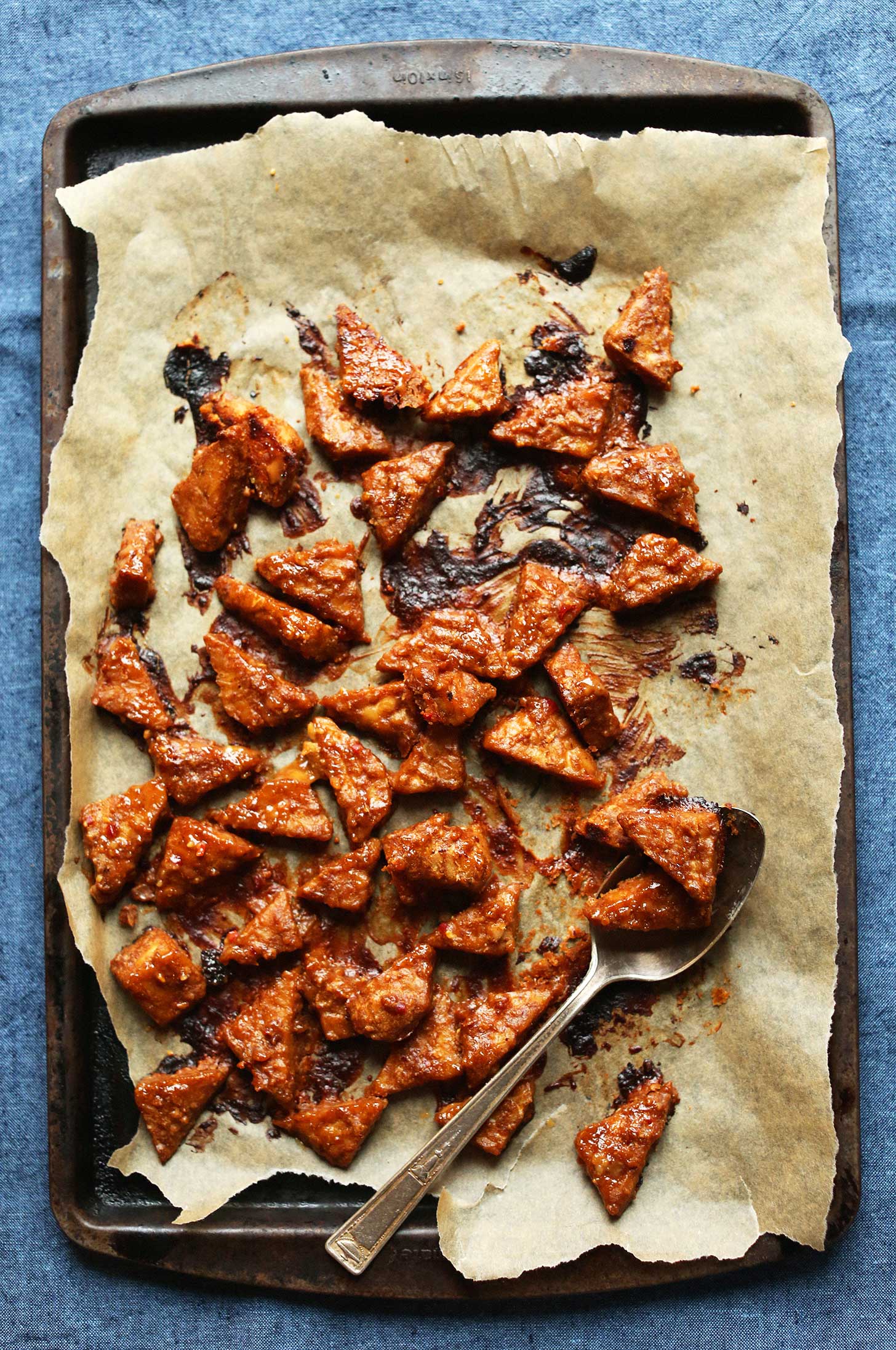 Parchment-lined baking sheet filled with our Marinated Peanut Baked Tempeh recipe