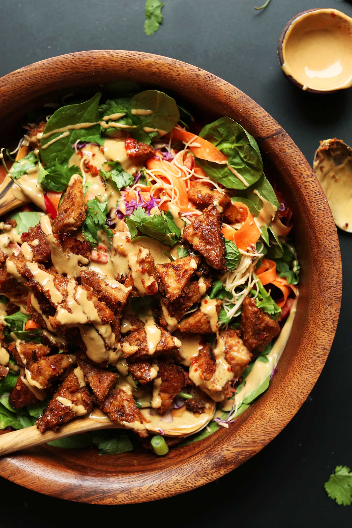 Wood bowl filled with gluten-free vegan Thai Salad with Marinated Peanut Tempeh