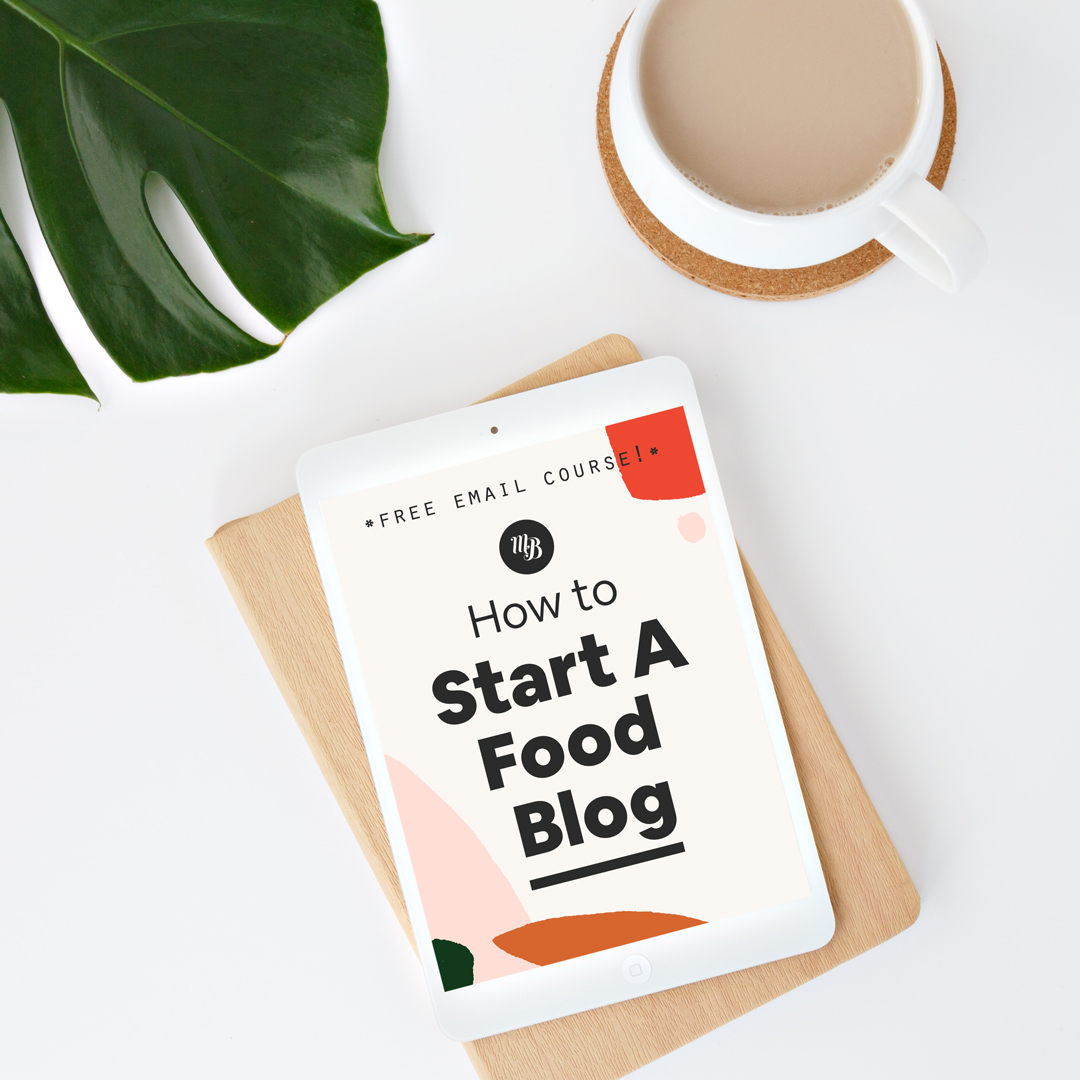 Mug of coffee next to a leaf and tablet with our How to Start a Food Blog course displayed