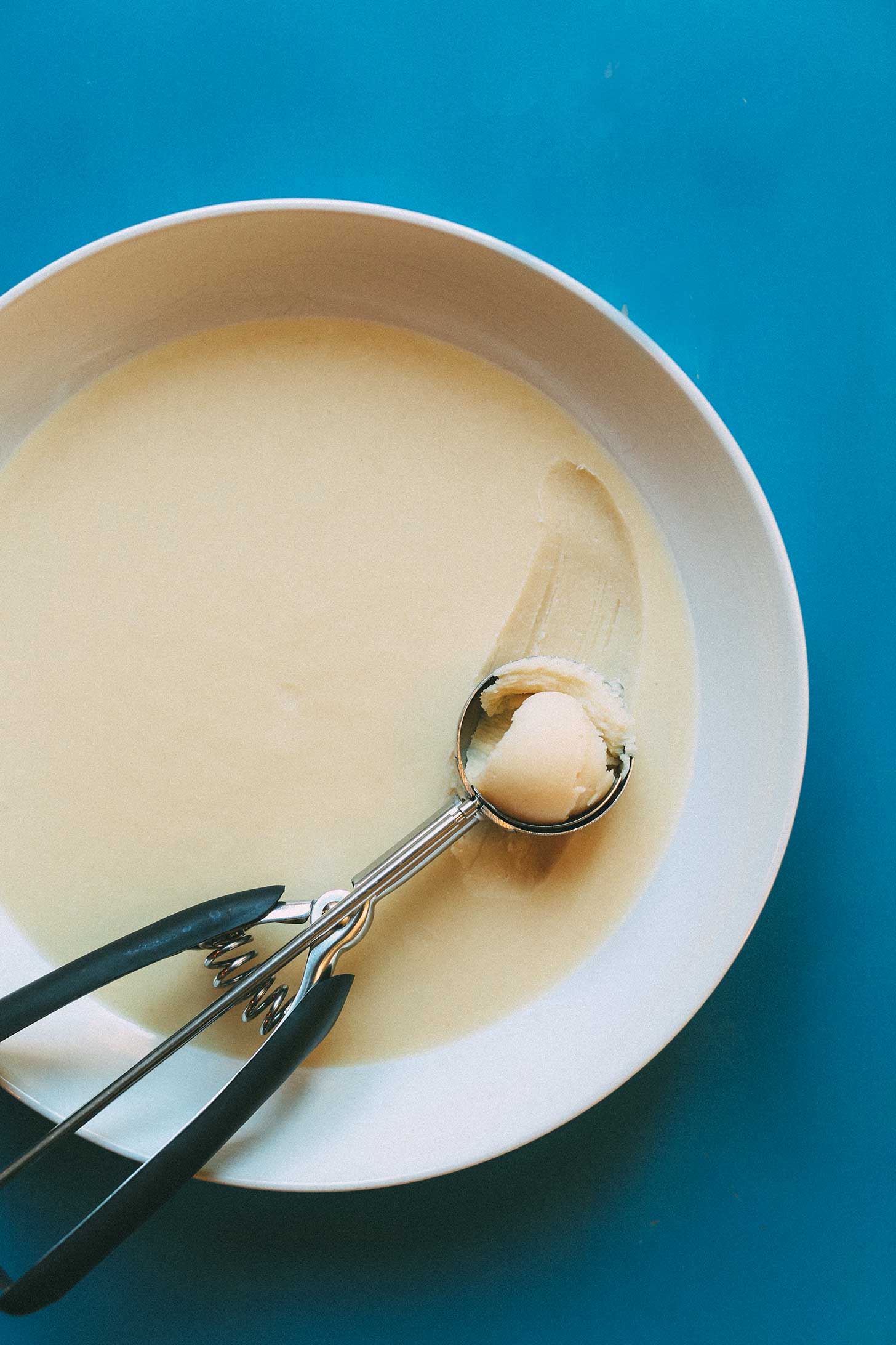 Using an ice cream scooper to grab some buttery Vegan White Chocolate Truffle mixture