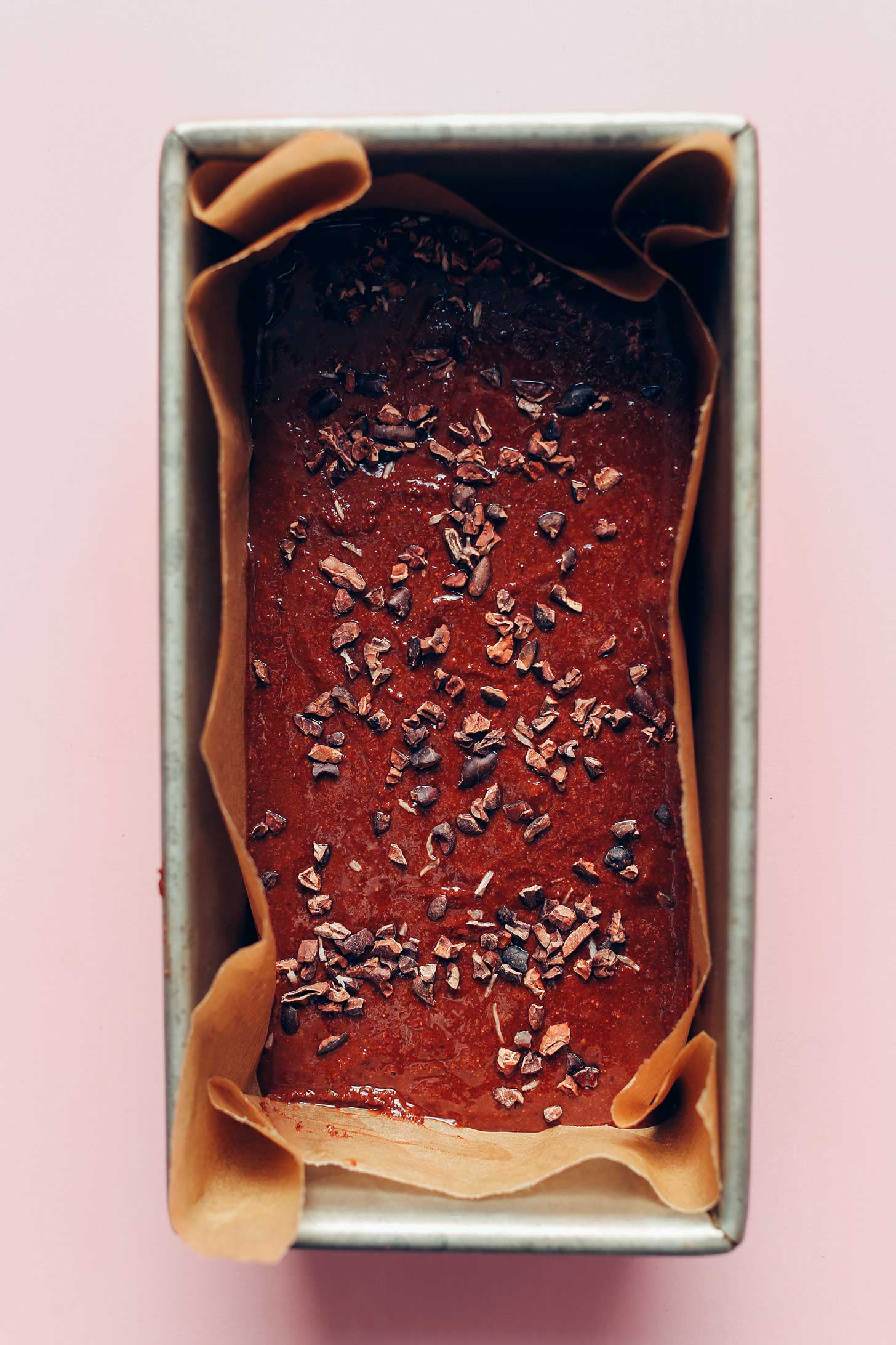 Parchment-lined bread pan filled with plant-based chocolate fudge
