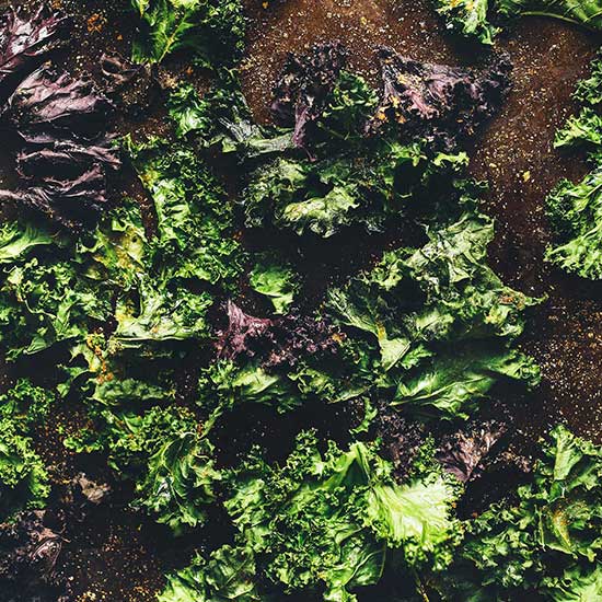 Baking sheet filled with a batch of kale chips for making healthy nachos