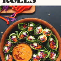 Bowls of fresh collard green salad rolls and sunflower butter dipping sauce